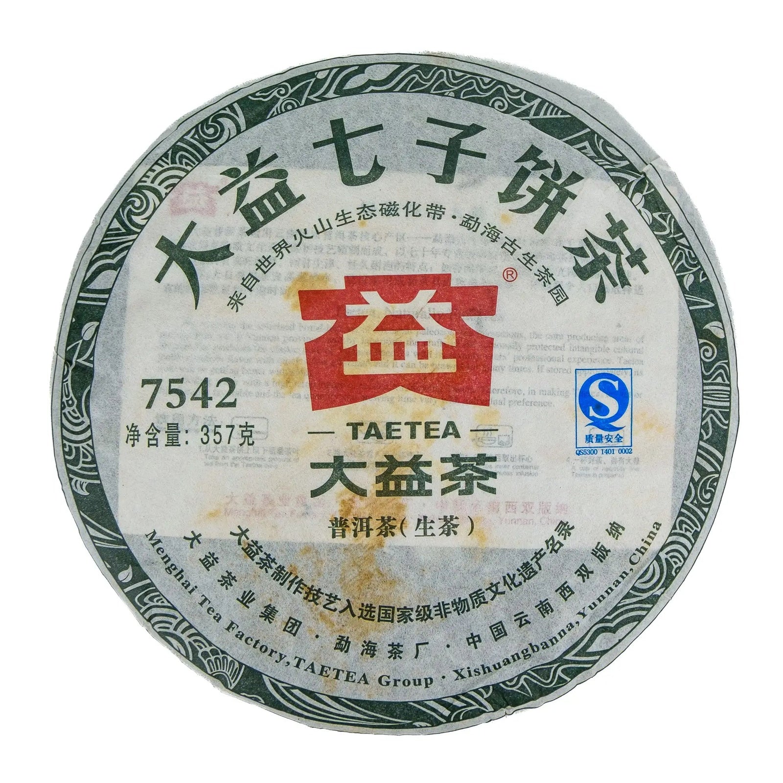 Front of the 2011 Dayi 7542 raw puerh cake wrapper, white paper with a green patterned border, the red Dayi logo and 7542 printed, with light staining