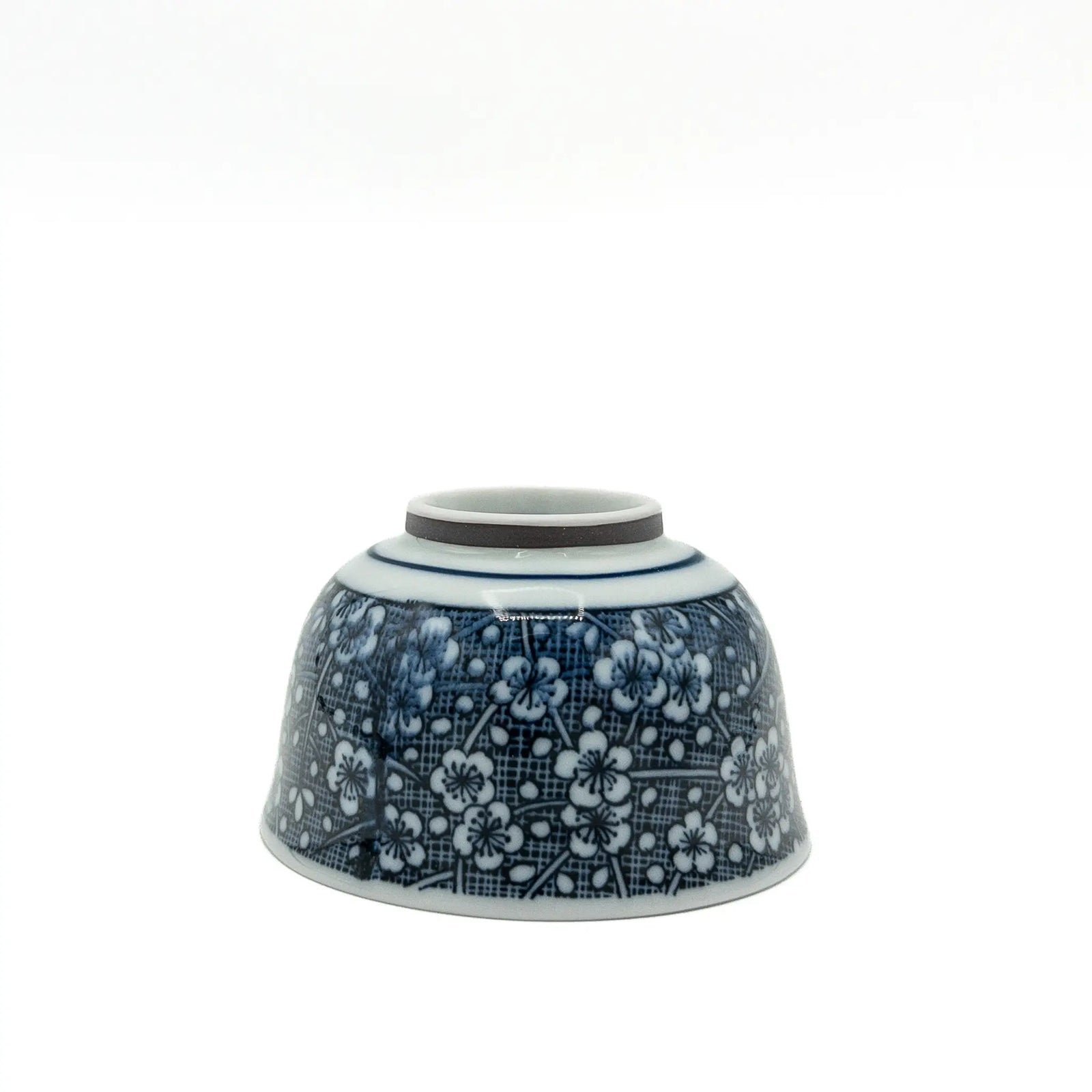 Porcelain Mino ware yunomi with white plum blossoms on a cobalt blue hatched ground - upside down view