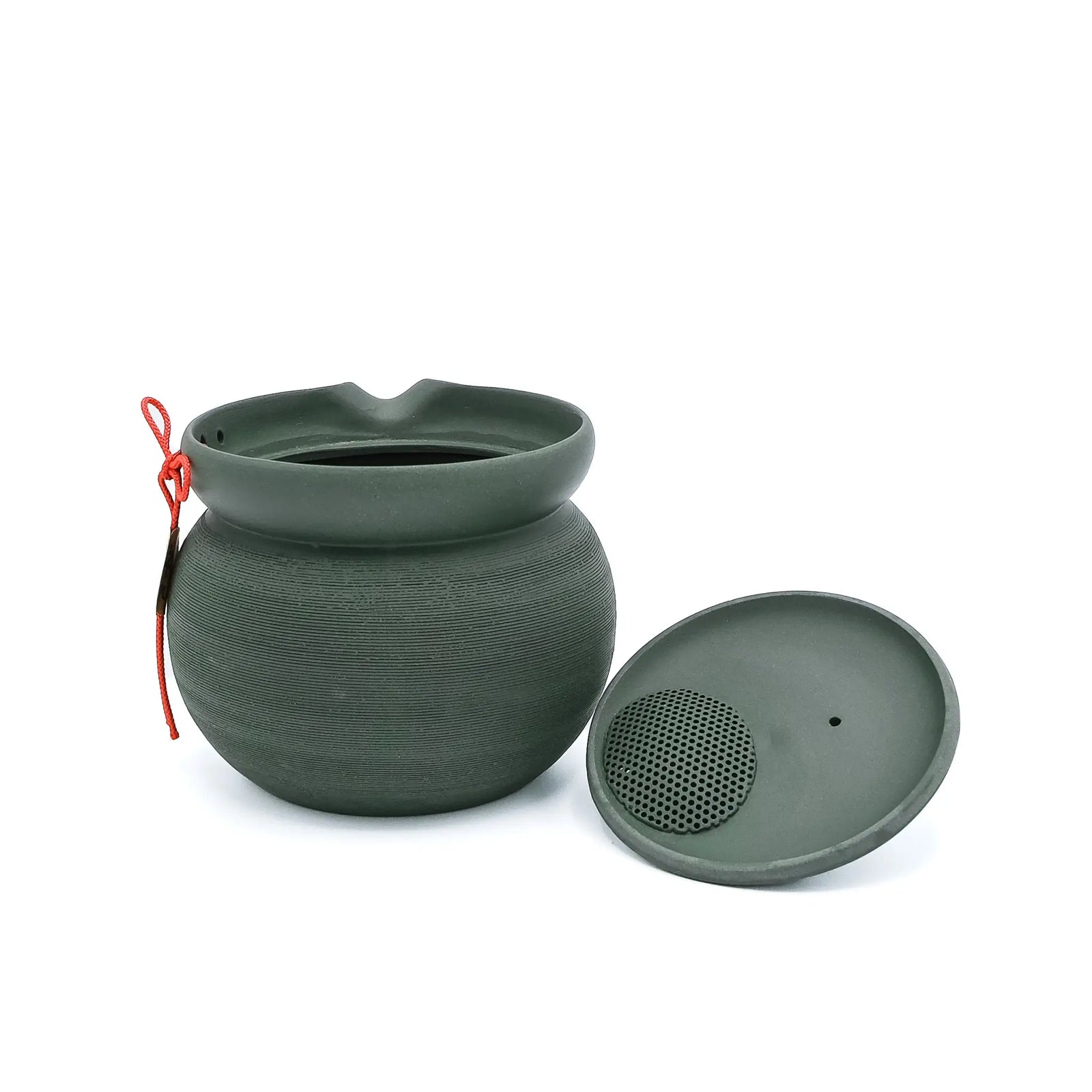 The green PUKU kyusu with its lid removed, showing the perforated ceramic strainer in the lid