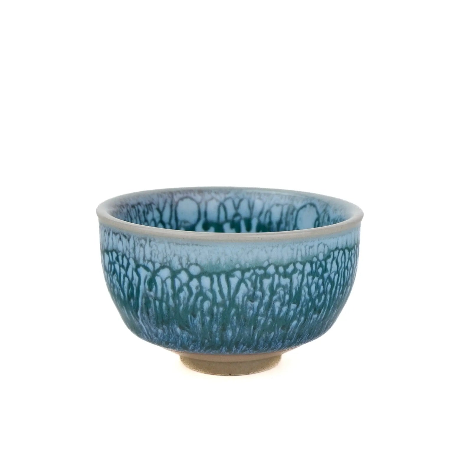 A ceramic tea cup with a textured, crackled glaze in shades of blue and teal, featuring a light beige base and rim, set against a plain white background.