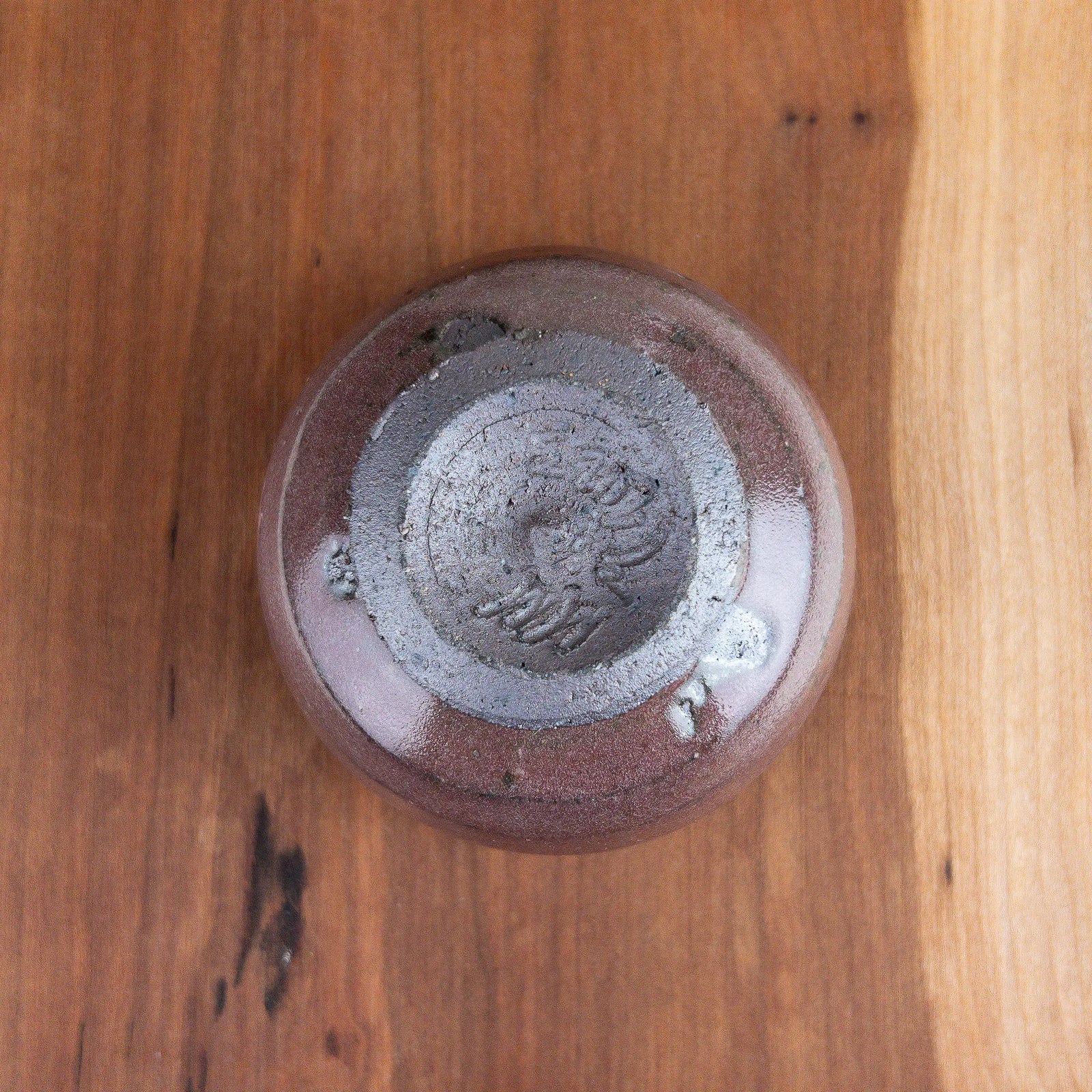 Ceramic cup on a wooden surface with a white background - Underside View