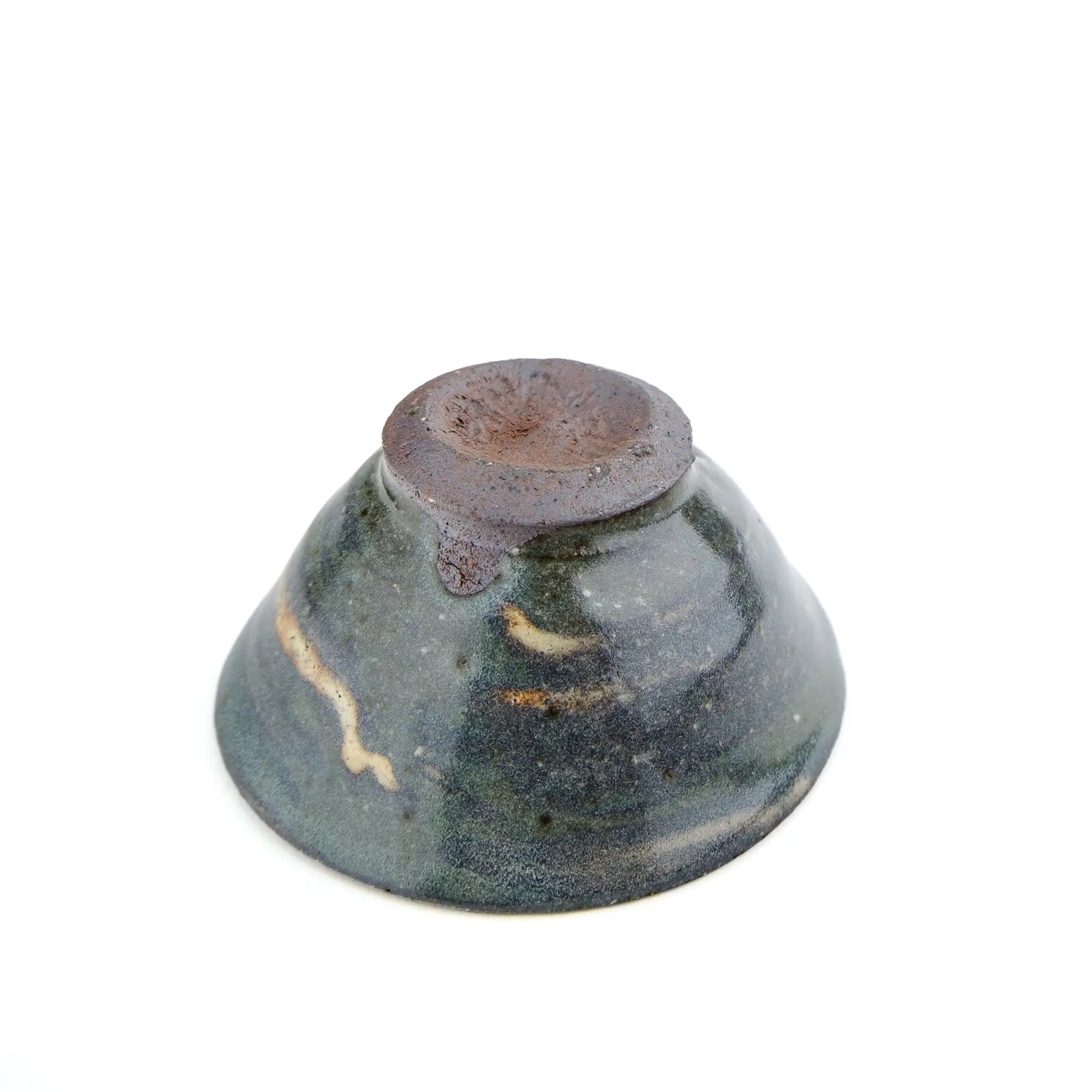 A handmade ceramic gong fu teacuip with a textured, speckled glaze - underside view of cup