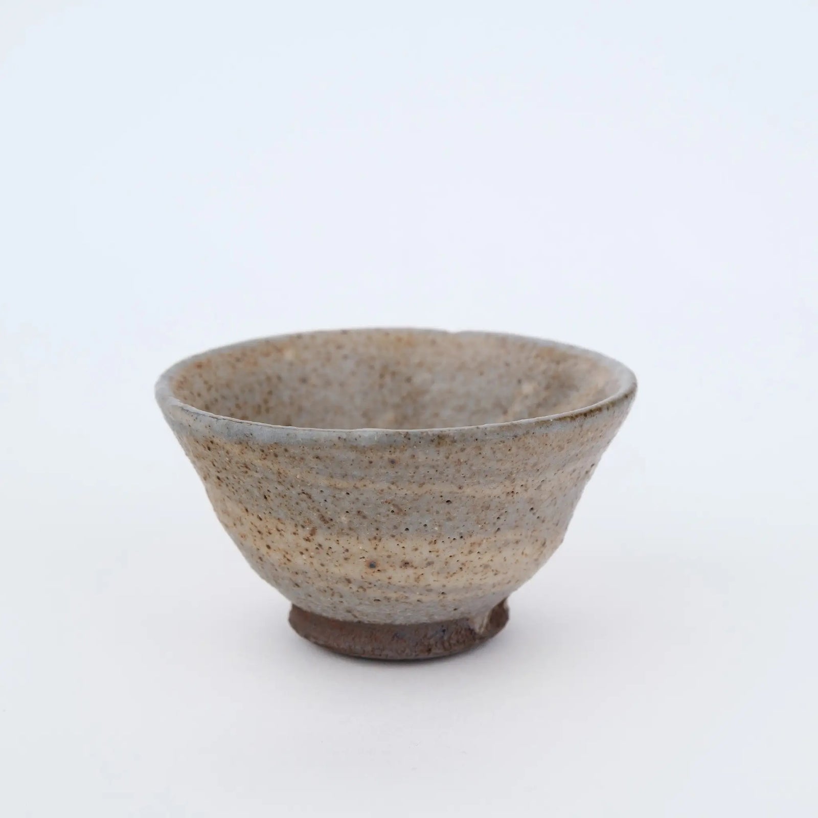 Ceramic teacup with speckled texture on a white background