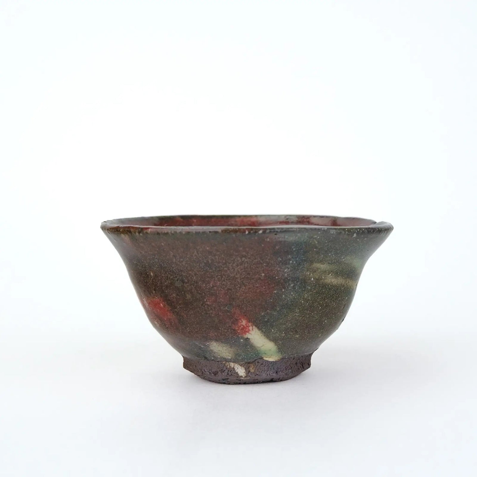 Mark Mohler gong fu cup #2C, about 50 ml, side view of the flared cup in a mottled grey green glaze with red and pale streaks and an unglazed foot