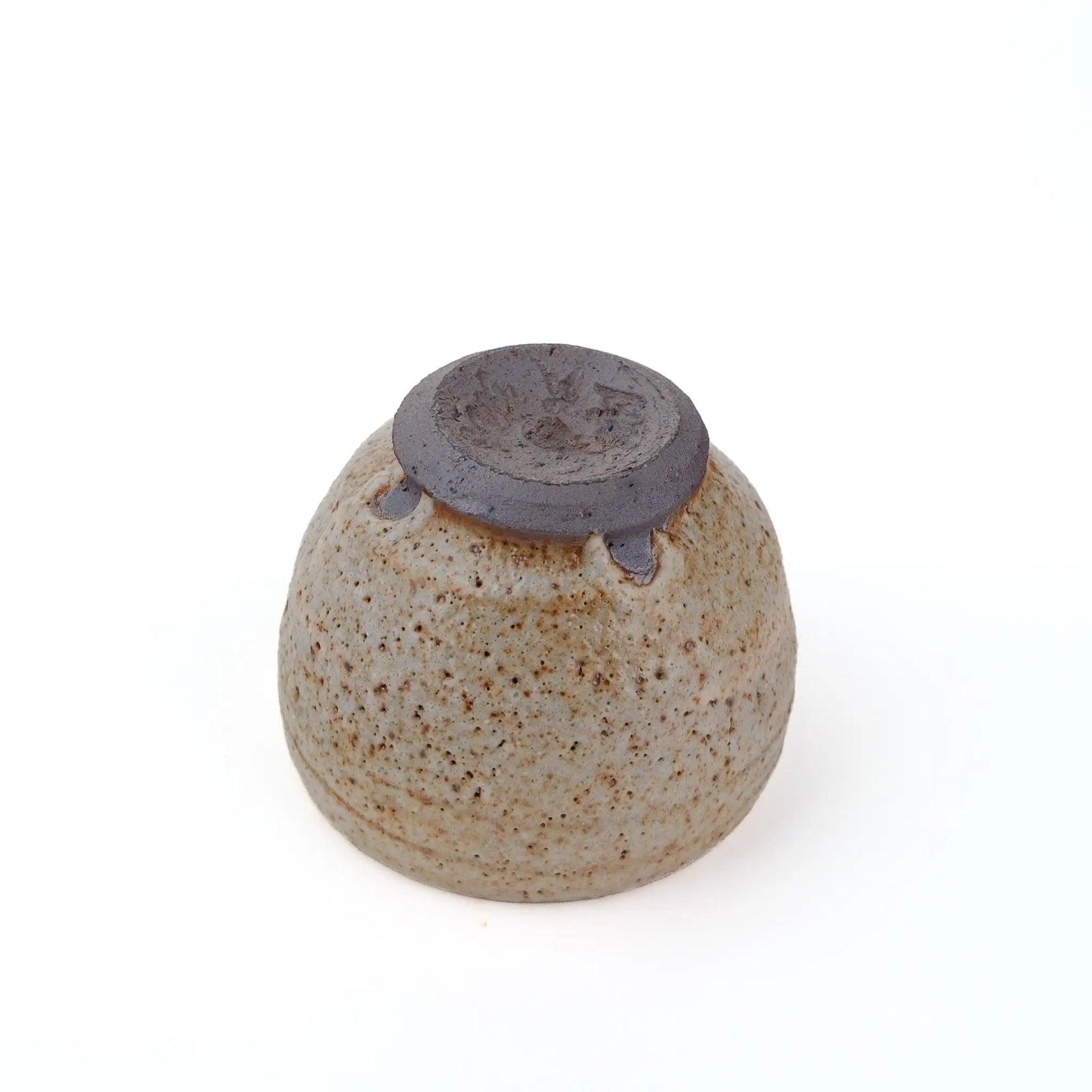 Mark Mohler handmade tea cup #N turned upside down, showing the unglazed dark foot ring and the glaze stopping just above it