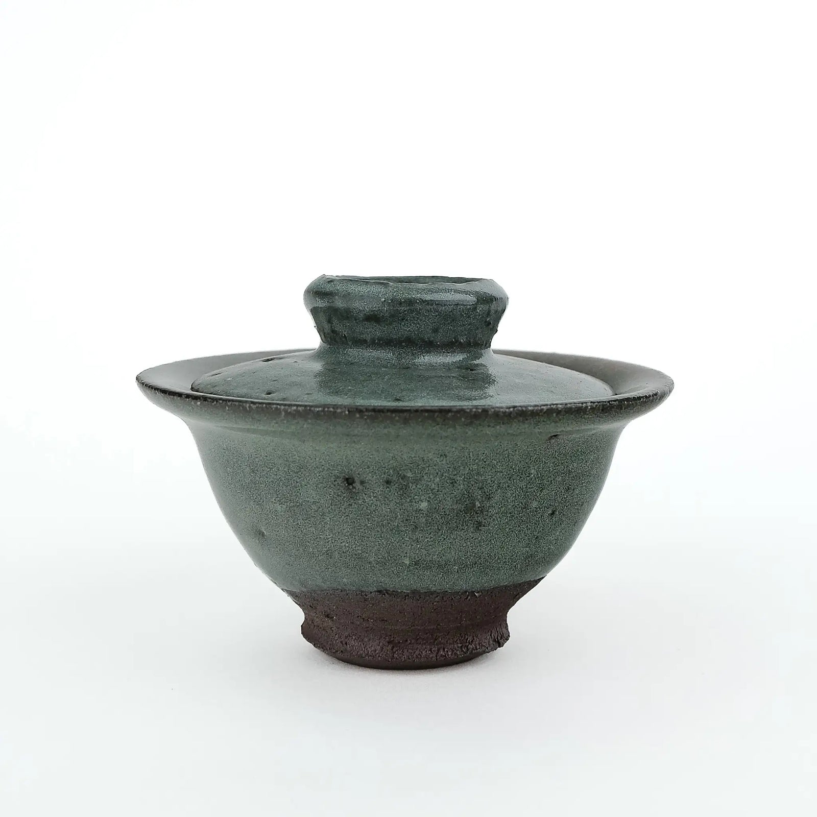 Mark Mohler handmade gaiwan #8 at eye level with the lid on, speckled green glaze ending above the dark unglazed foot