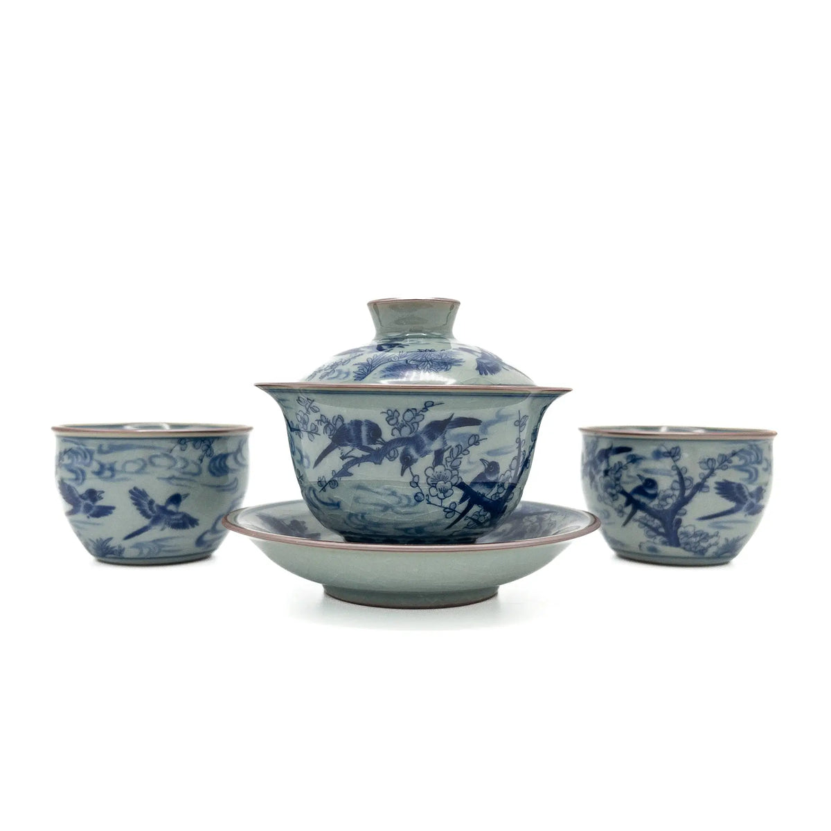 Blue and celadon-toned porcelain gaiwan set with lid, saucer, and two matching teacups featuring hand-painted birds and plum blossoms