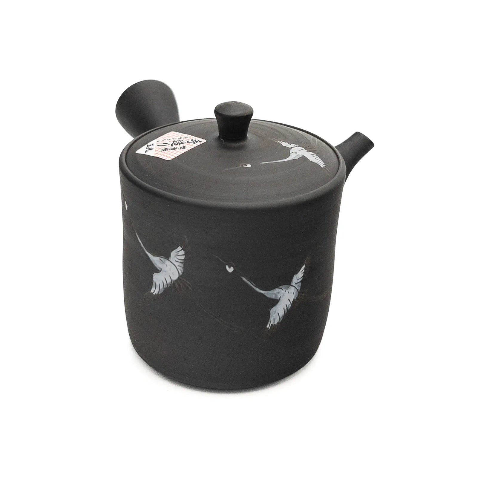Black ceramic teapot with bird designs on a white background