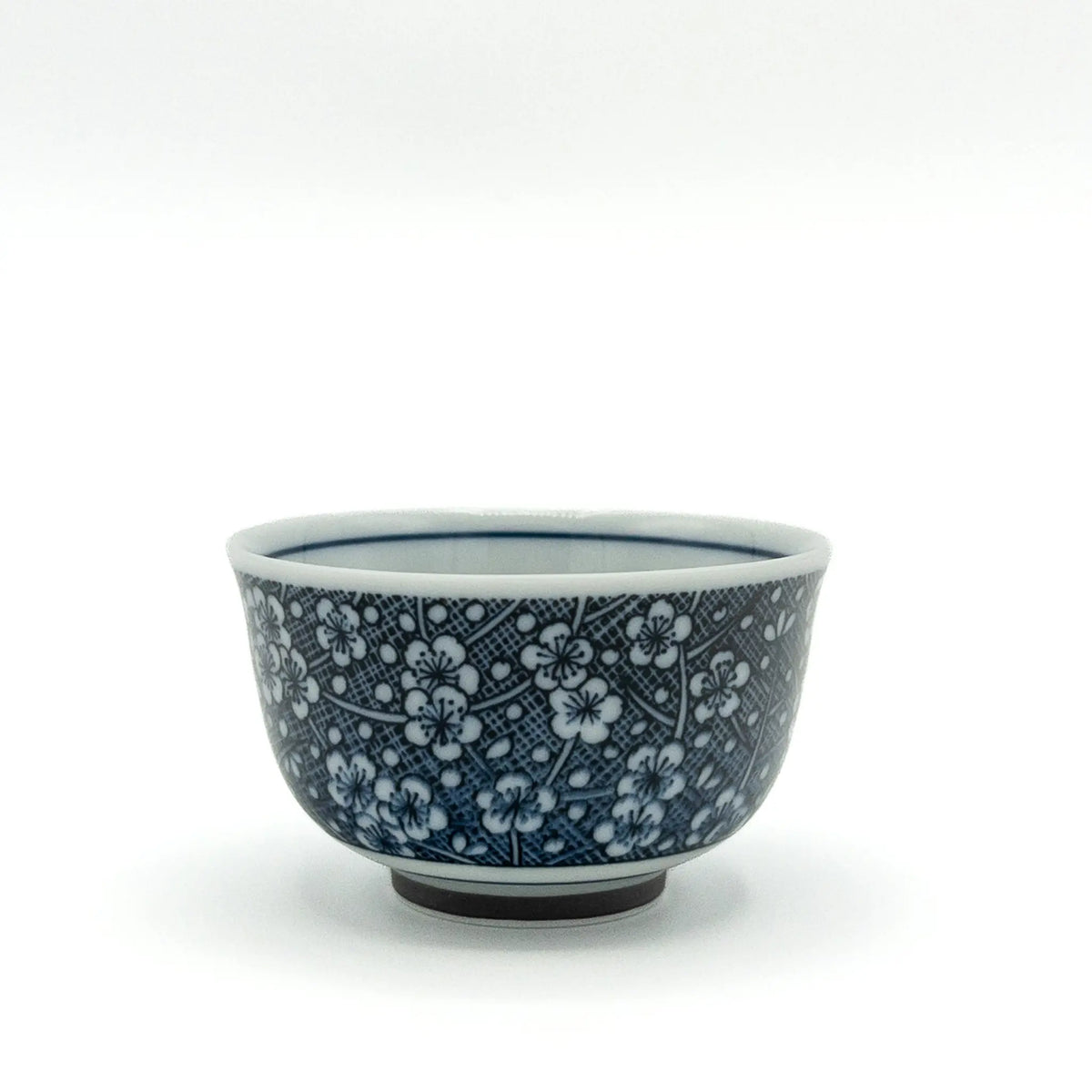 Porcelain Mino ware yunomi with white plum blossoms on a cobalt blue hatched ground
