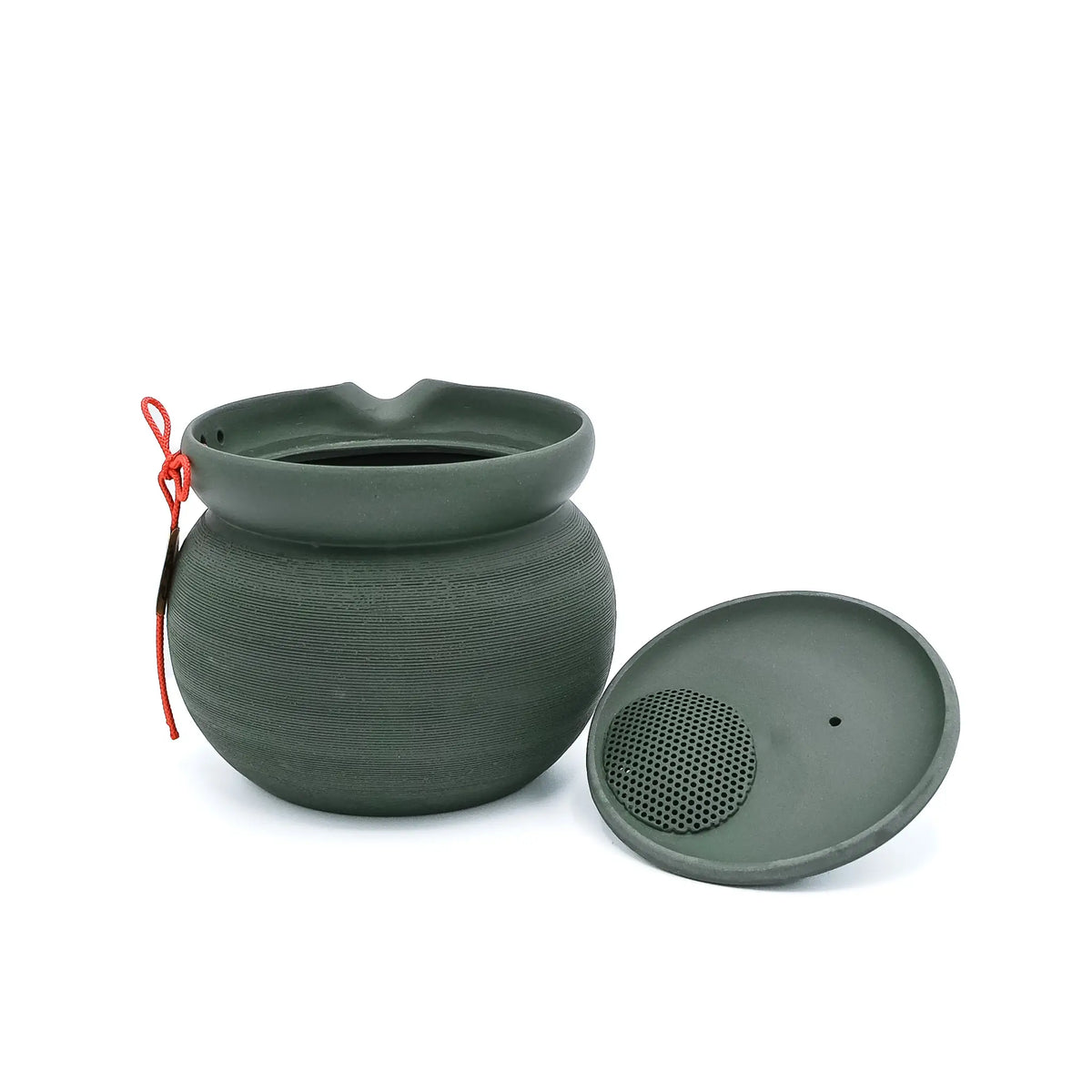 The green PUKU kyusu with its lid removed, showing the perforated ceramic strainer in the lid