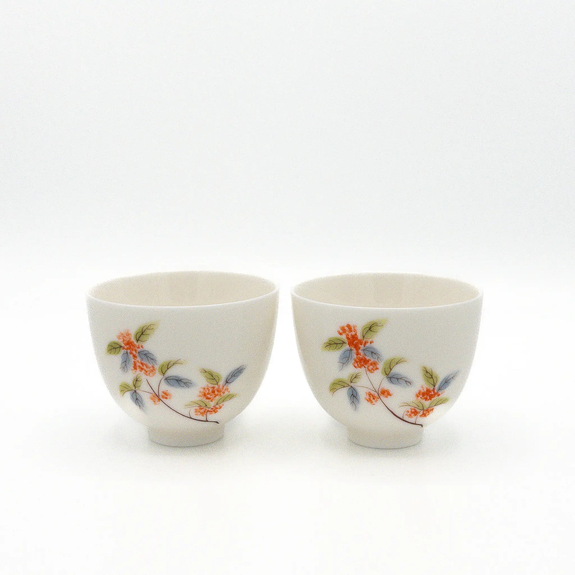 Two ceramic cups with floral designs on a white background