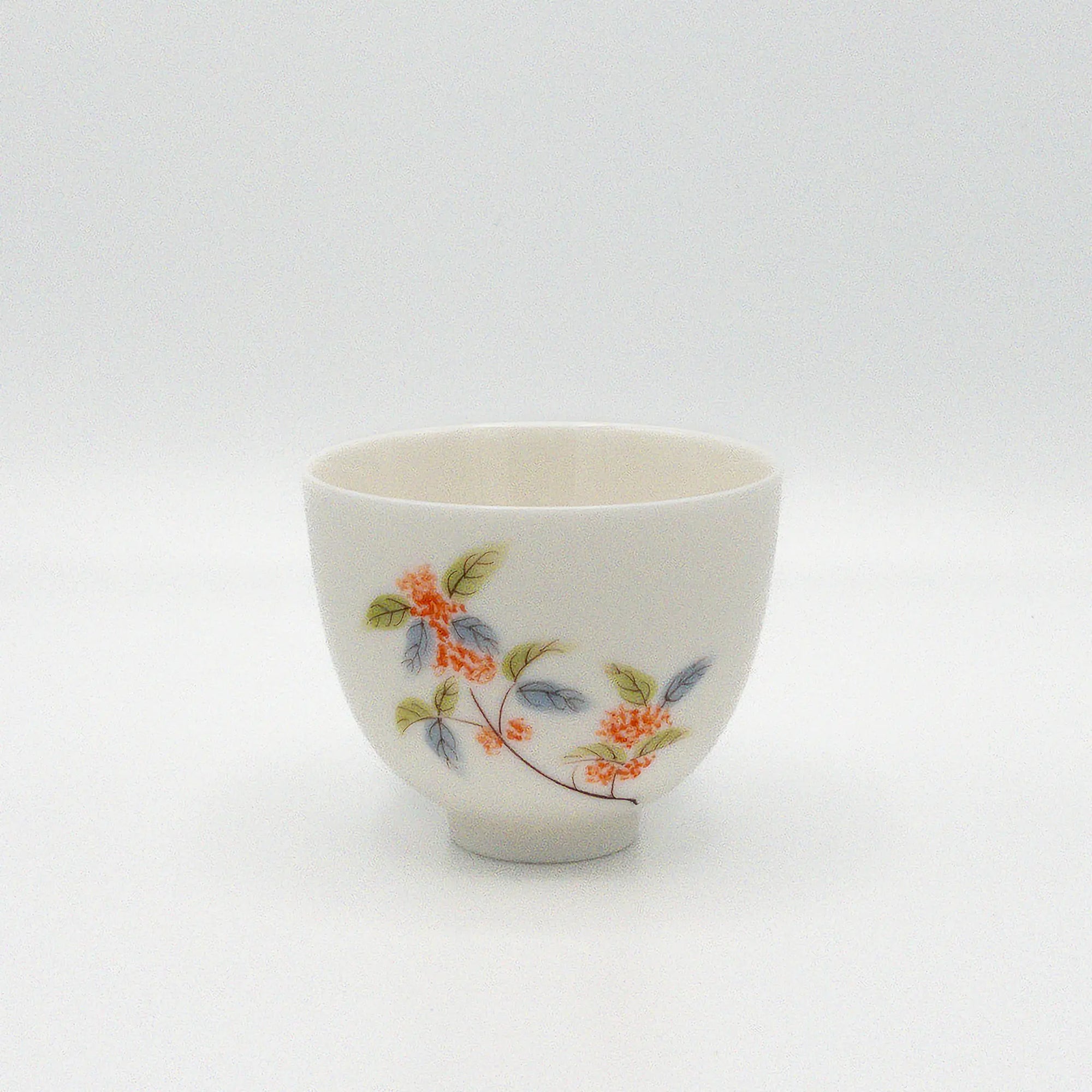 White ceramic cup with floral design on a white background