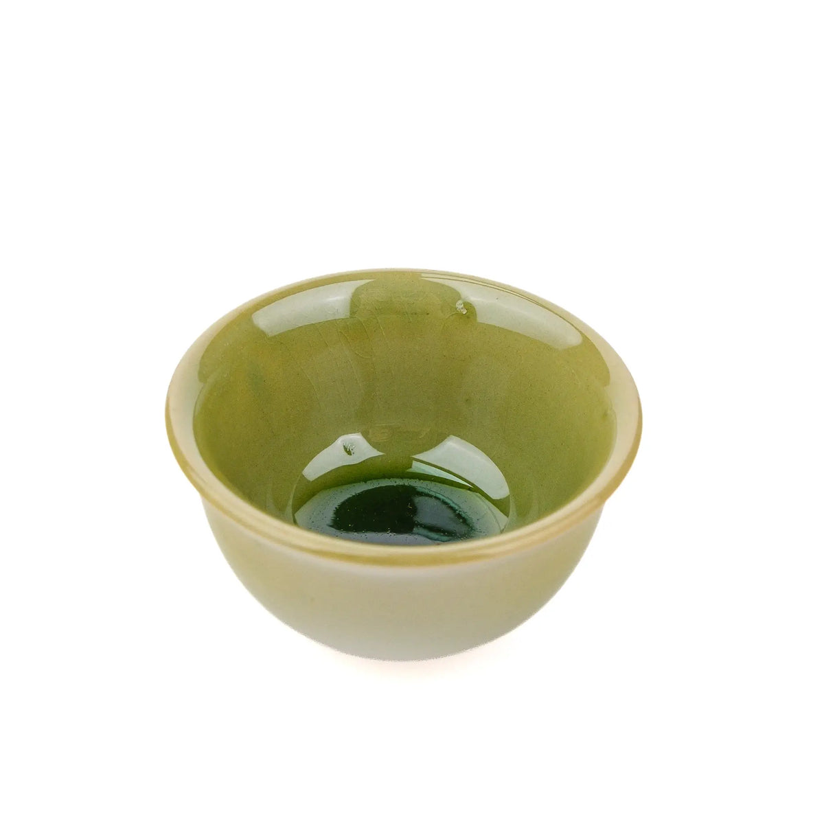 Small cup for gong fu tea with green glaze on a white background