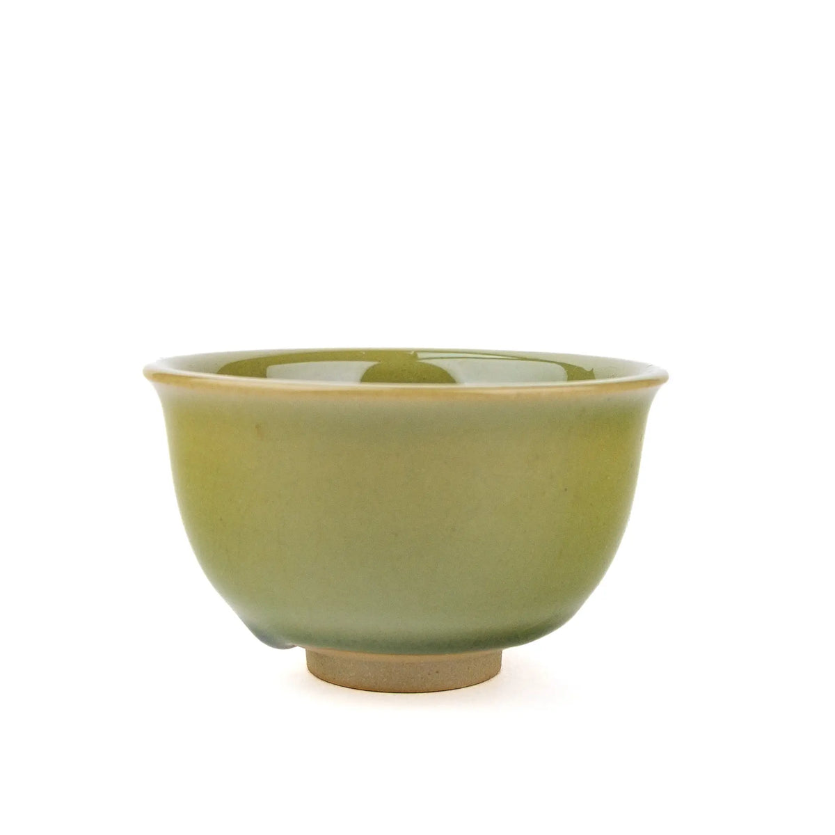 Small cup for gong fu tea with green glaze and slight pooling at the bottom on a white background