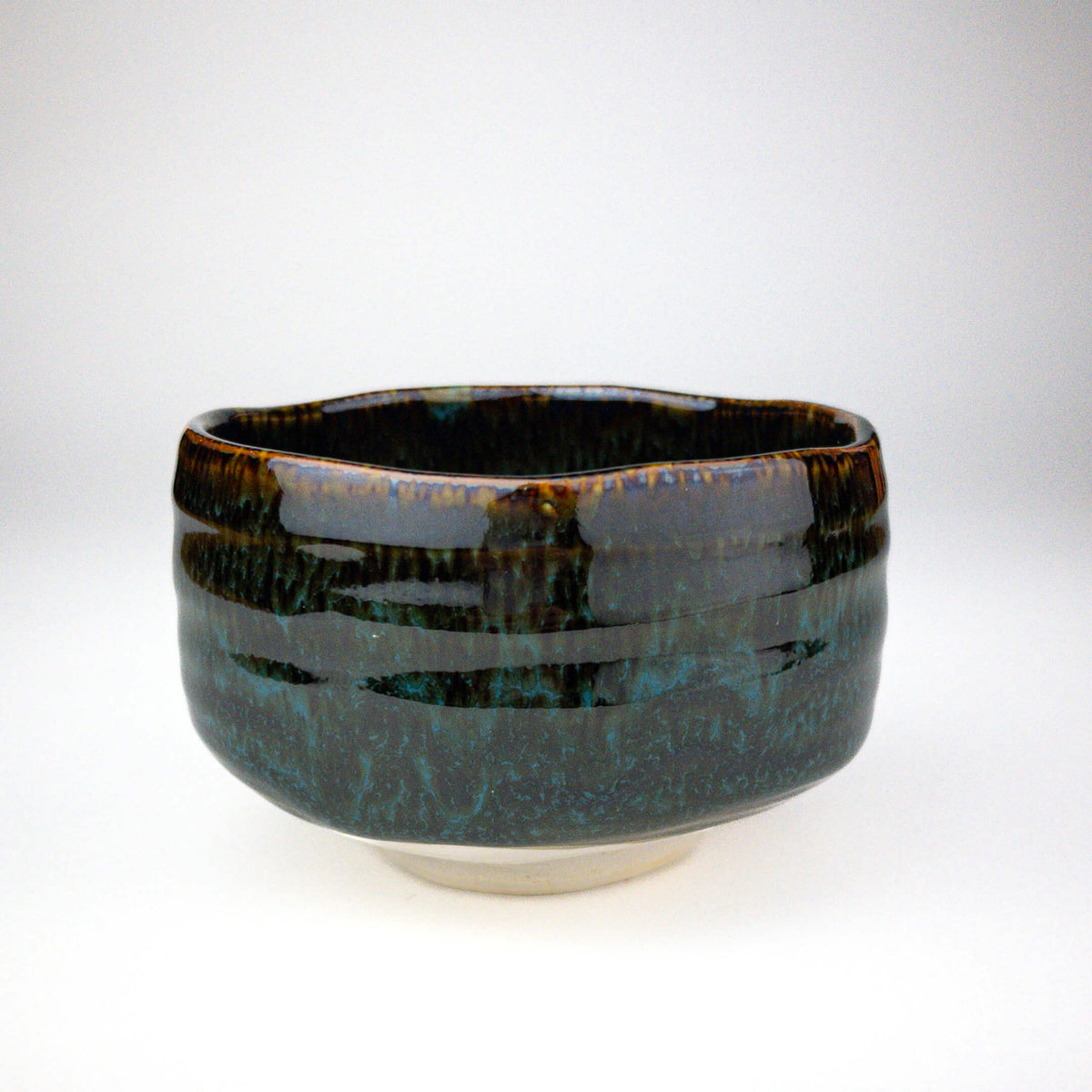 Ceramic bowl with a glossy black and blue glaze on a white background