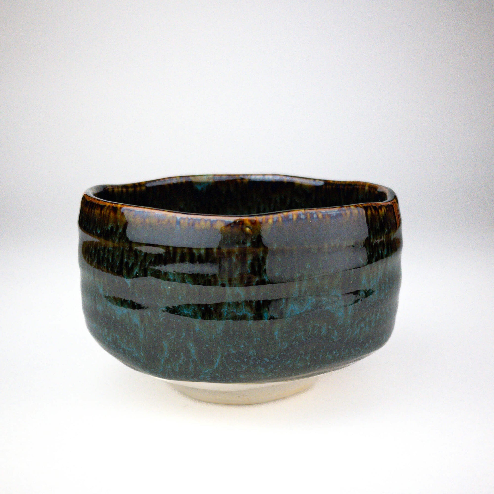 Ceramic bowl with a glossy black and blue glaze on a white background
