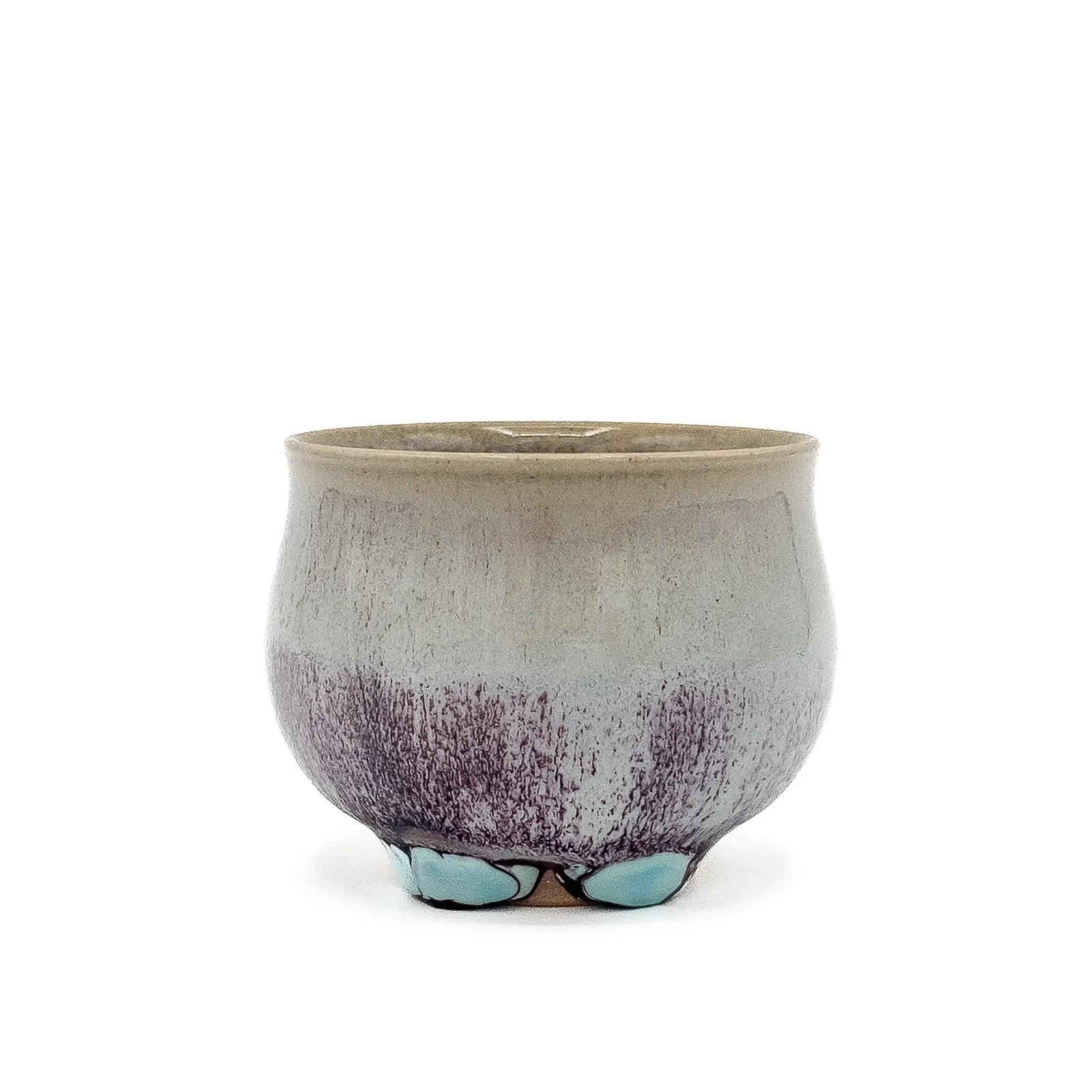 Ceramic teacup with speckled design on a white background
