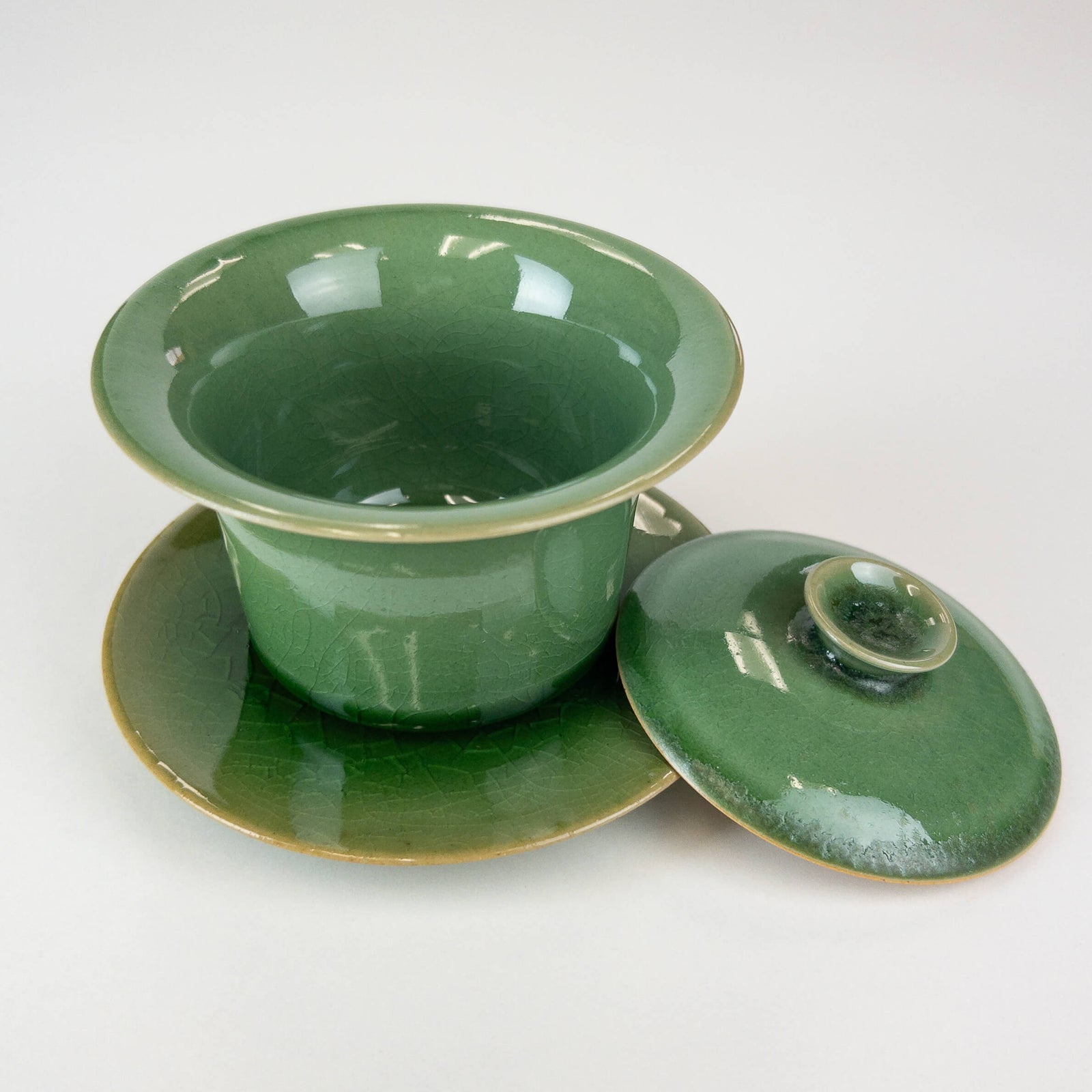 Green ceramic gaiwan with lid on a white background