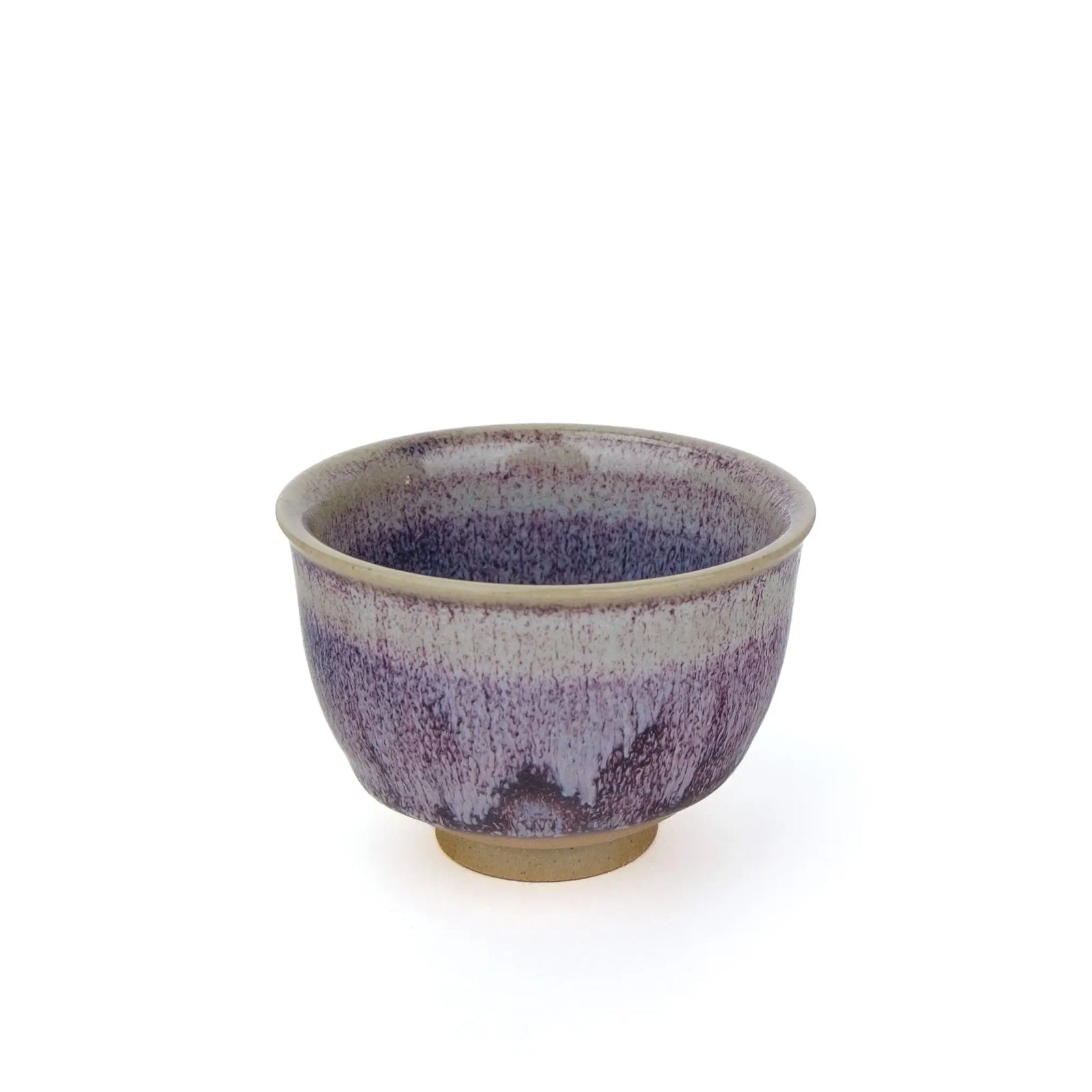 A ceramic tea handmade teacup with a purple and white glaze pattern and a natural beige clay base, shown against a plain white background.