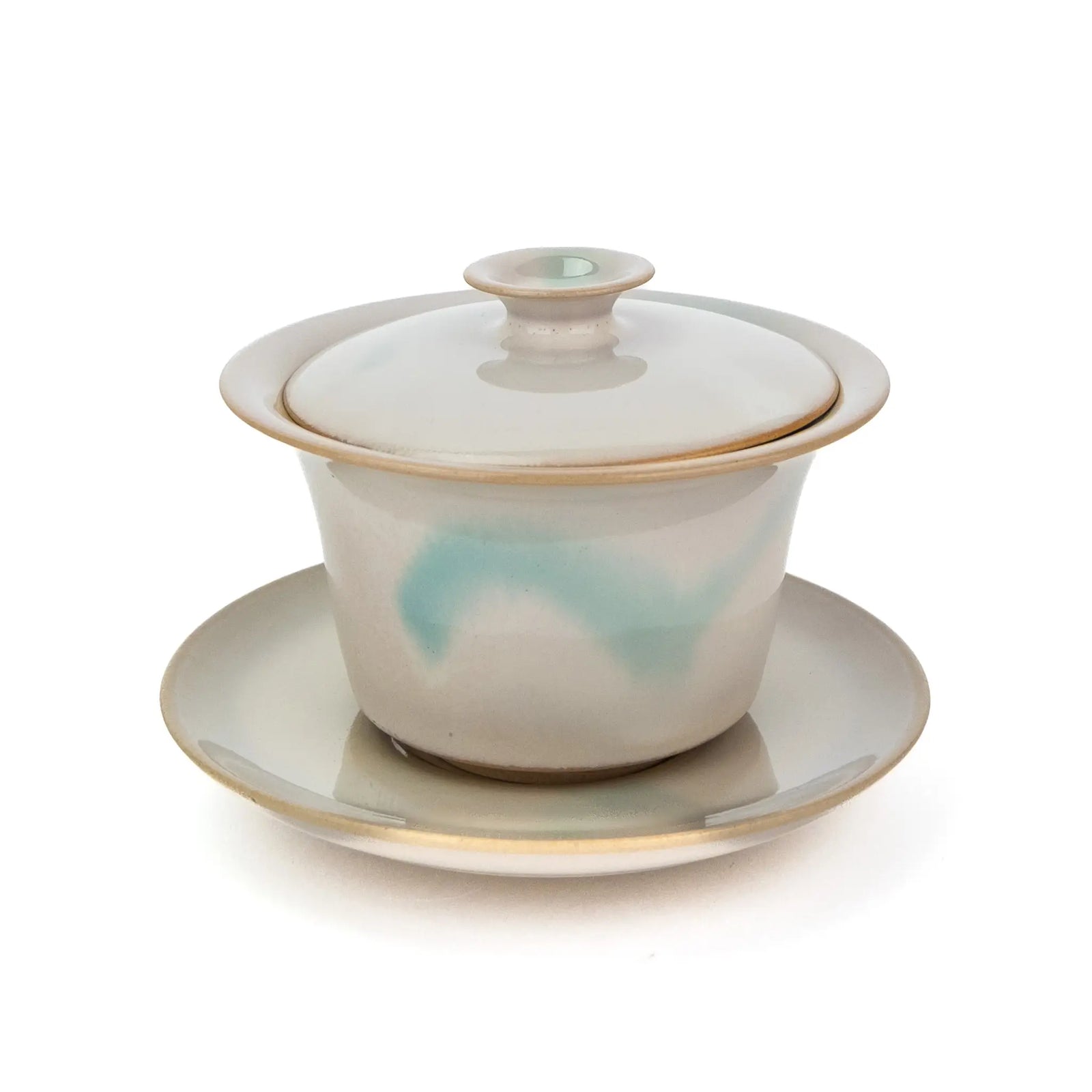 A slightly overhead view of a Huaning pottery handmade gaiwan with a white glaze and a little bit of blue on the body.