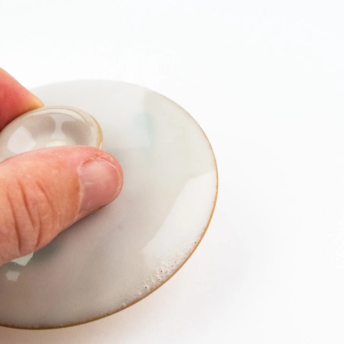 A close up of the edge of the gaiwan lid that shows a small amount of bubbling in the glaze.