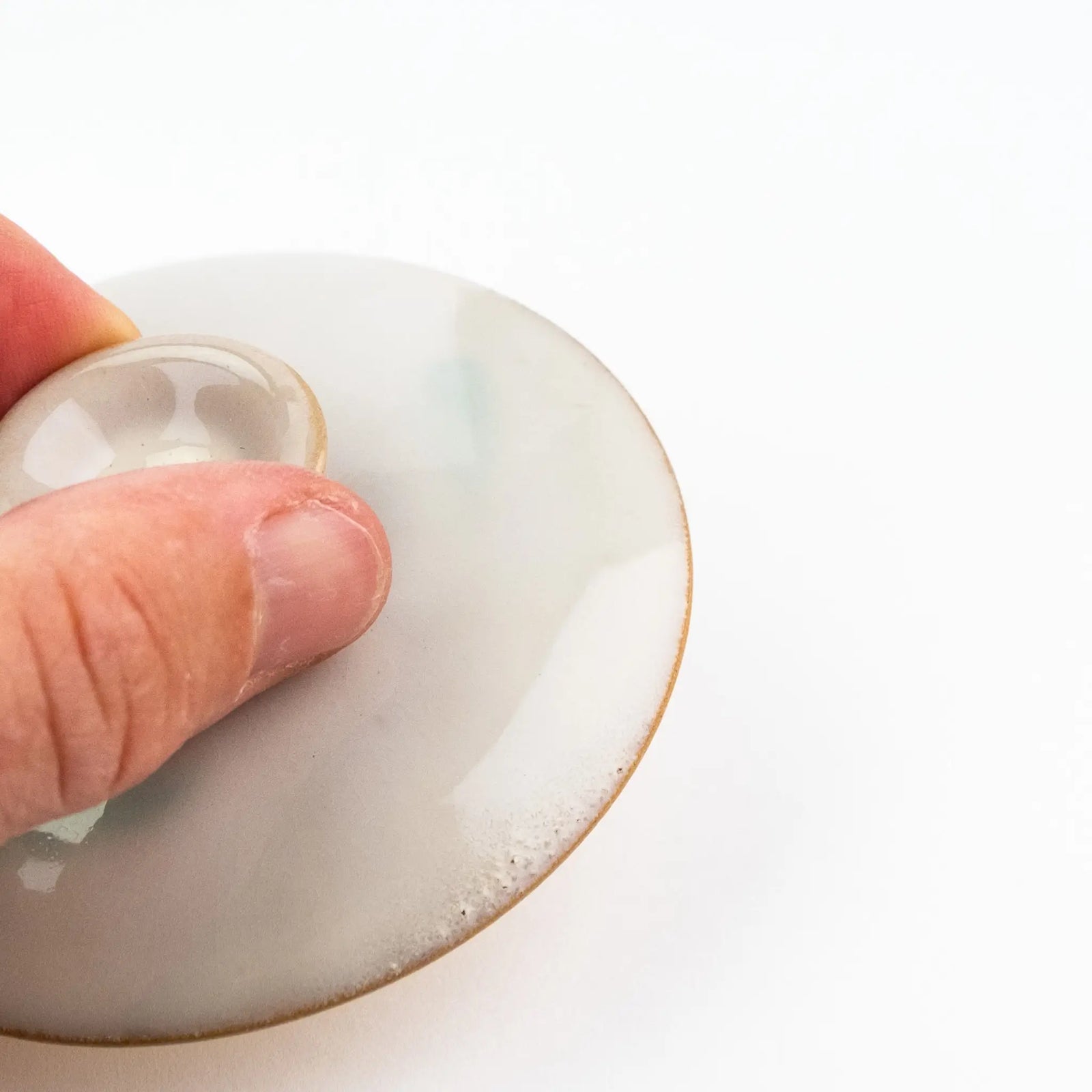 A close up of the edge of the gaiwan lid that shows a small amount of bubbling in the glaze.