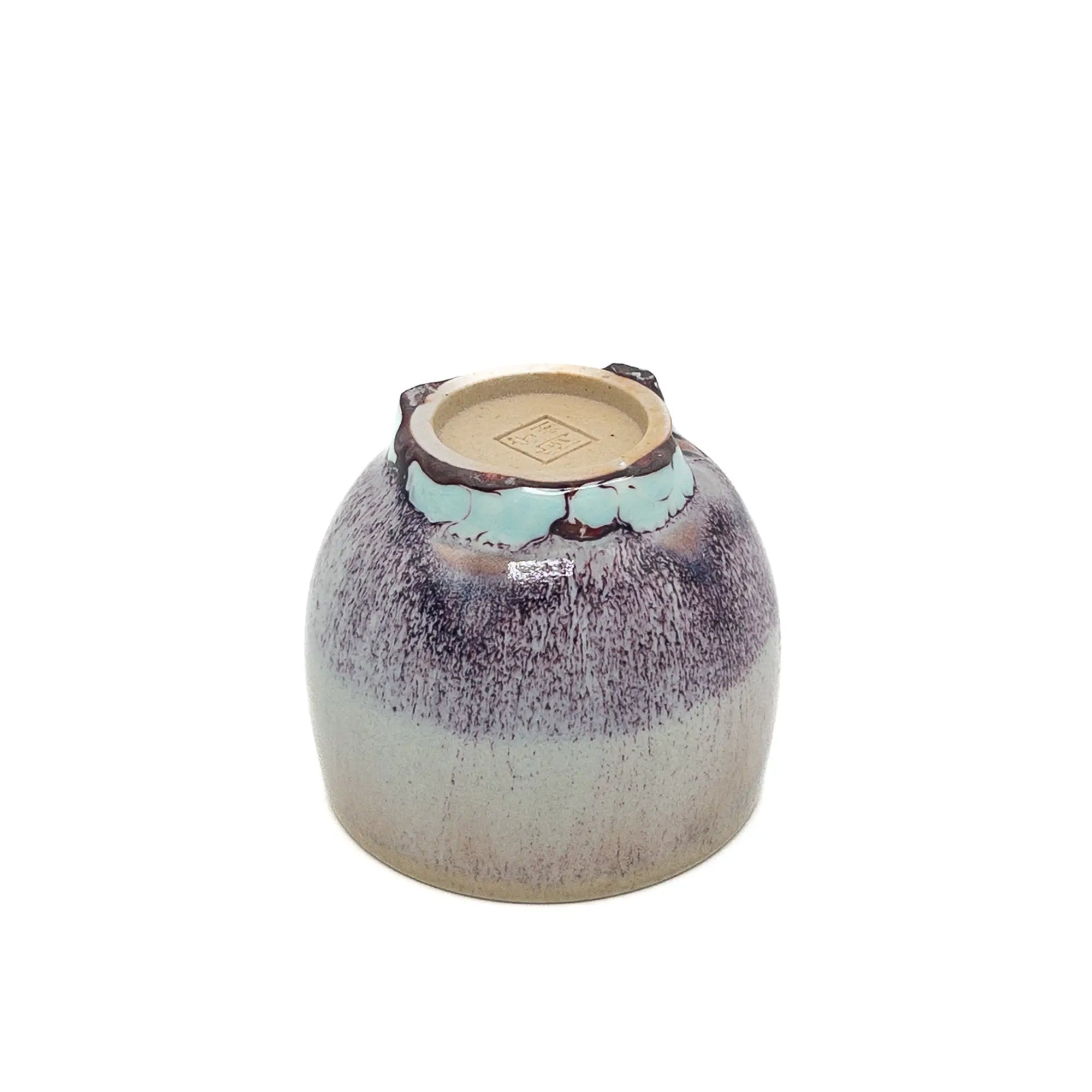 Ceramic cup with speckled design on a white background