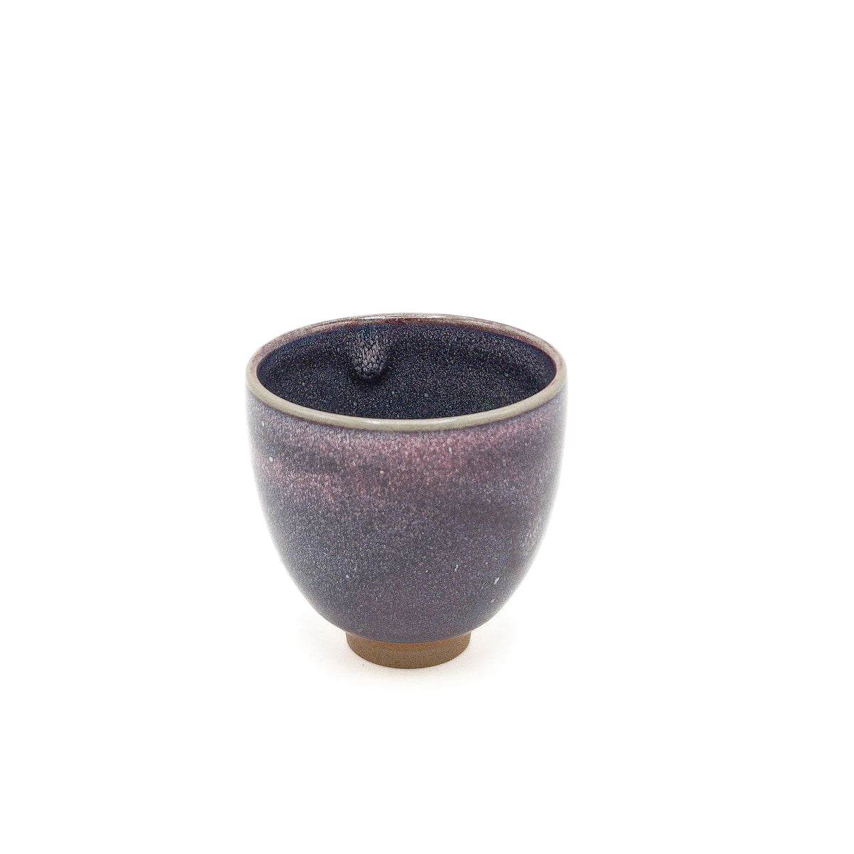 Small ceramic cup with purple glaze on a white background