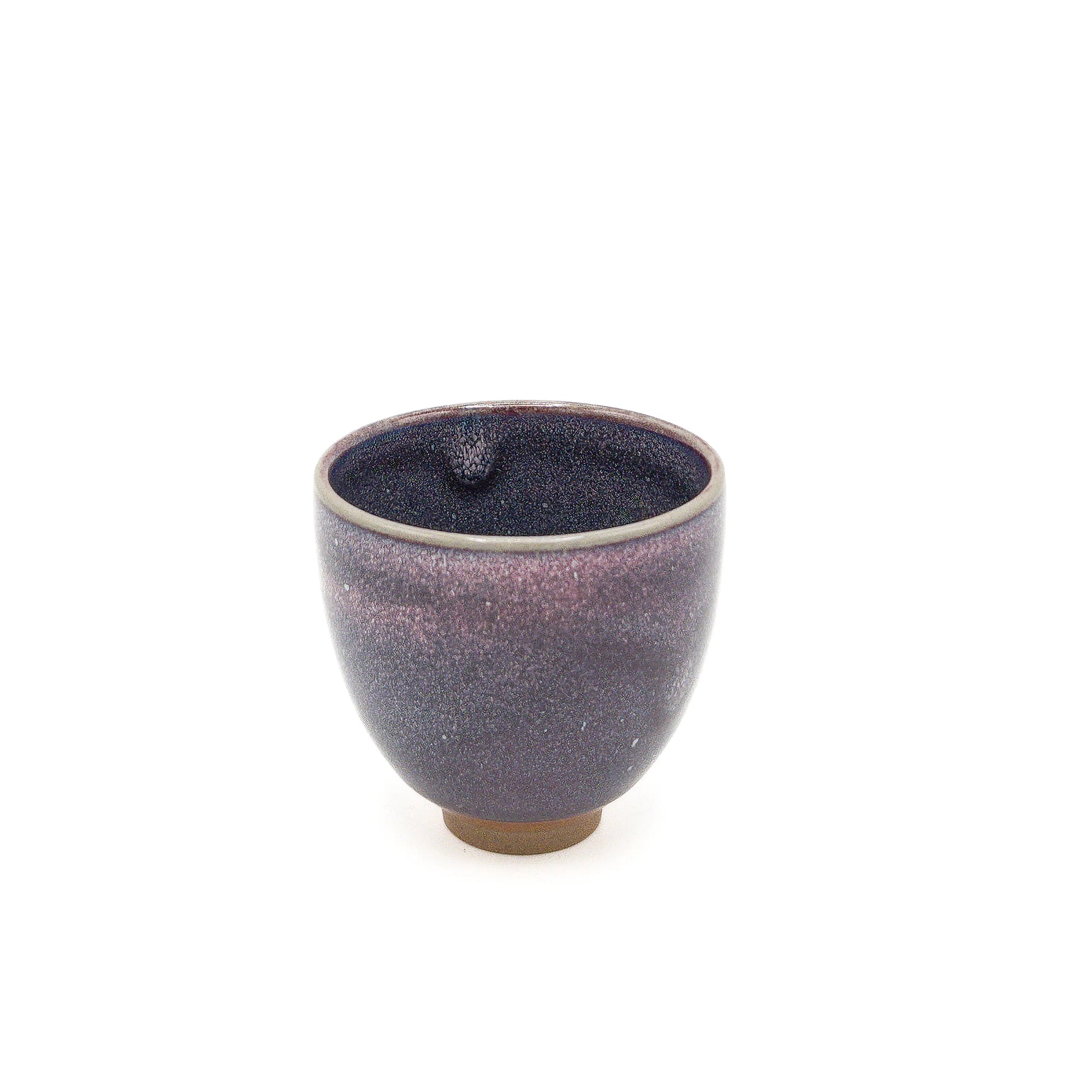 Small ceramic cup with purple glaze on a white background