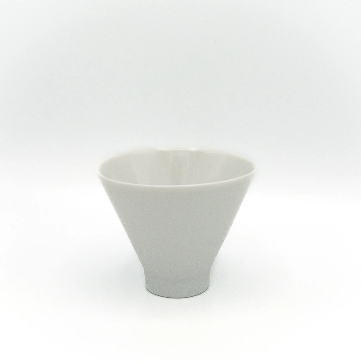 White ceramic cup in an inverted cone shape on a white background