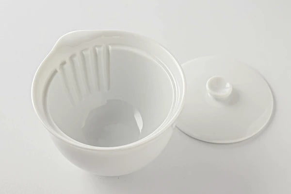 White ceramic hohin with lid on a white background