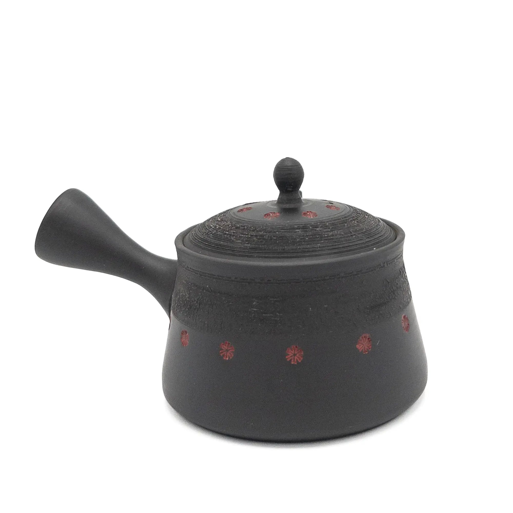 Black teapot with red patterns on a white background