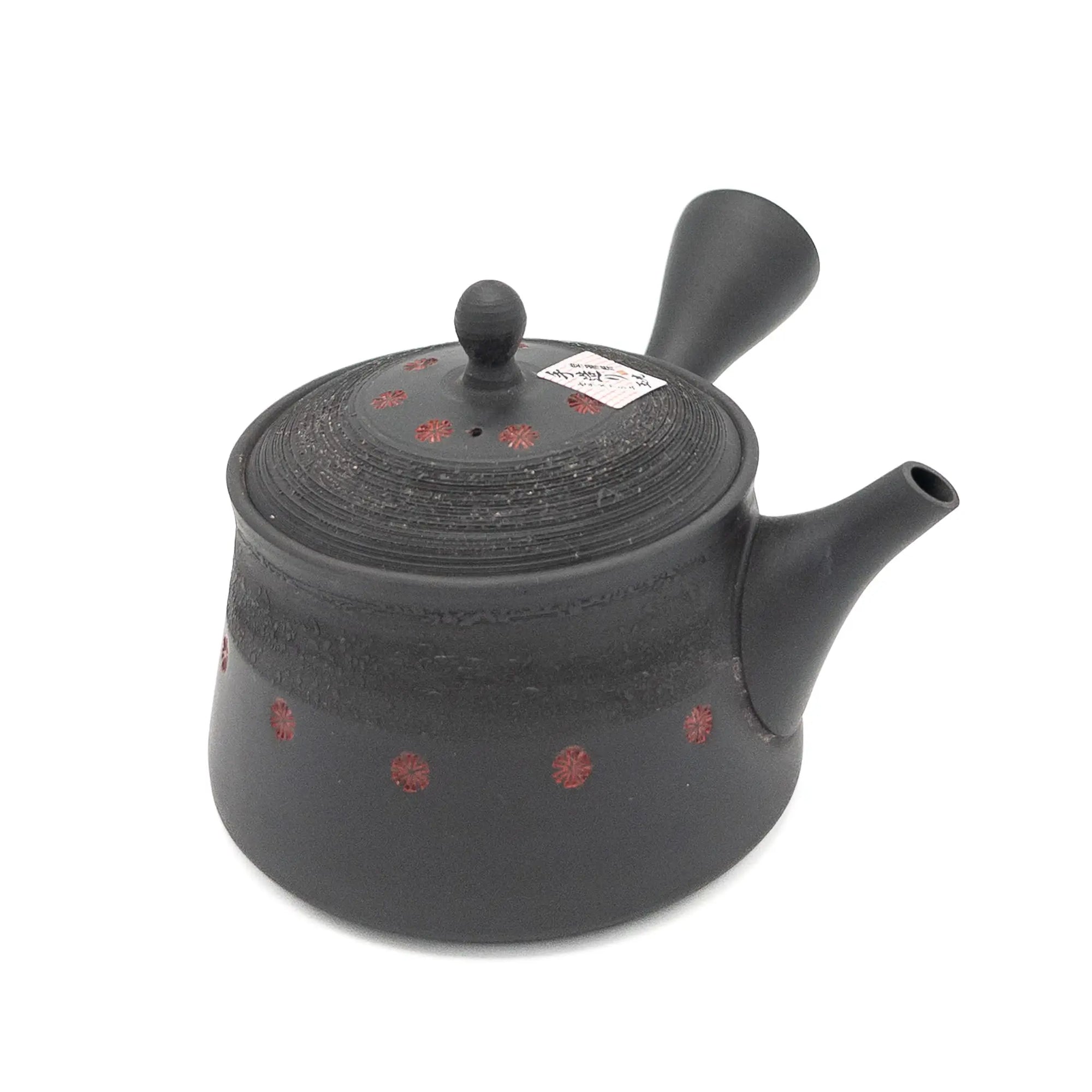 Black teapot with red patterns on a white background
