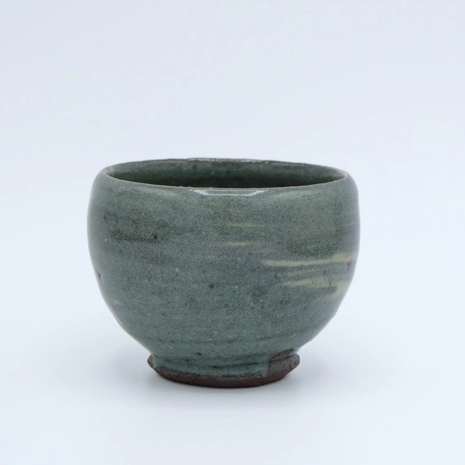 Greenish ceramic cup with striped pattern on a white background