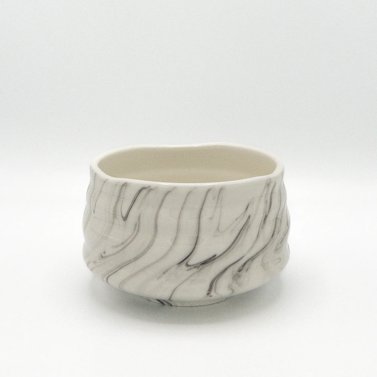 Marble-patterned ceramic matcha bowl on a white background