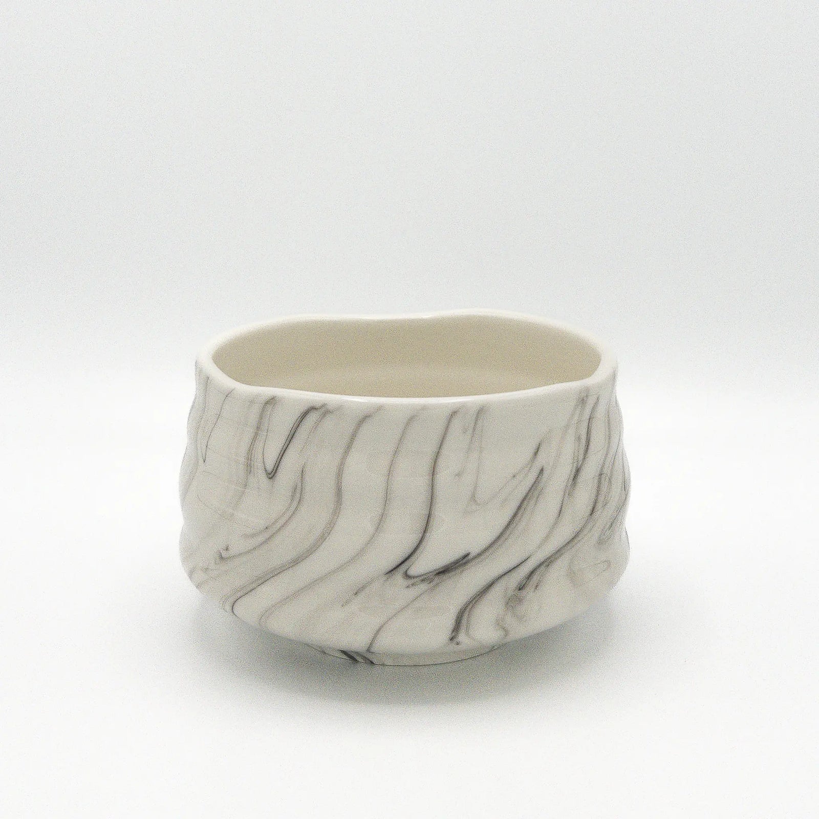 Marble-patterned ceramic matcha bowl on a white background
