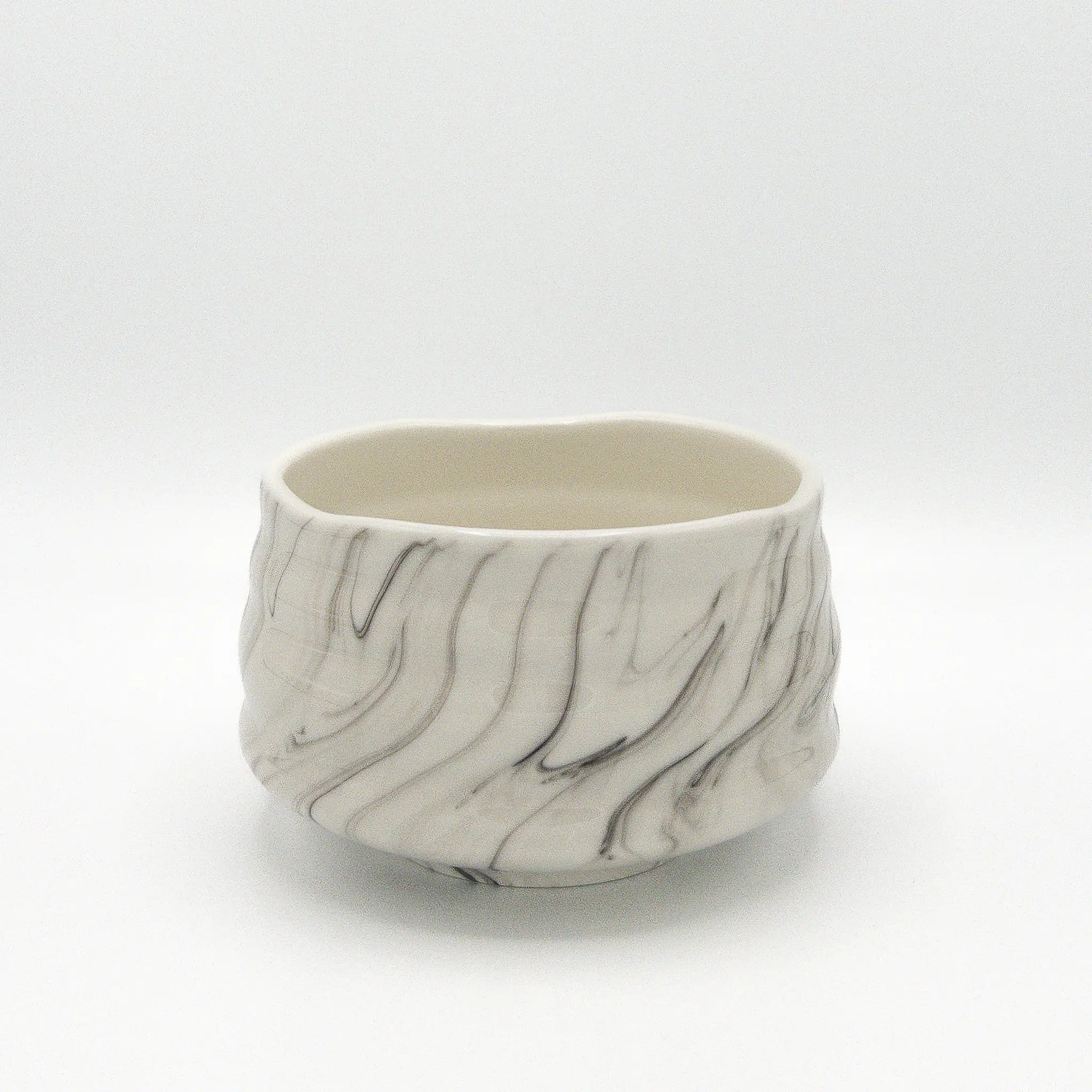 Marble-patterned ceramic matcha bowl on a white background