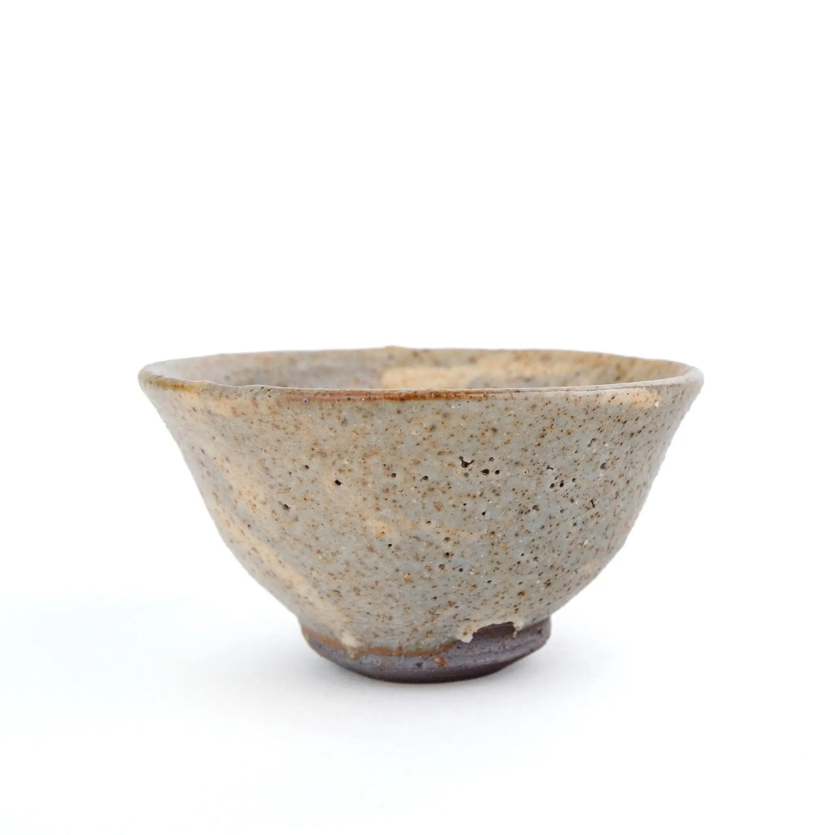 A handmade ceramic gong fu teacup with a textured, speckled glaze in earthy beige and brown tones, set against a plain white background.