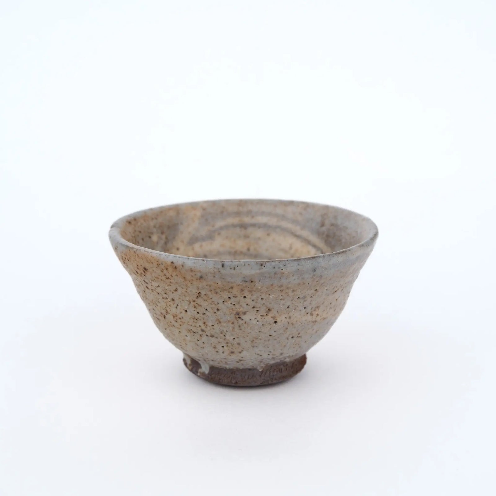 Ceramic teacup with speckled texture on a white background