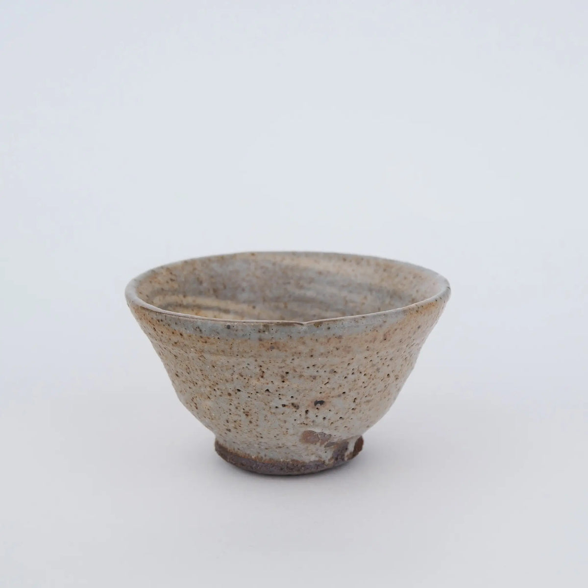 Ceramic teacup with speckled texture on a white background