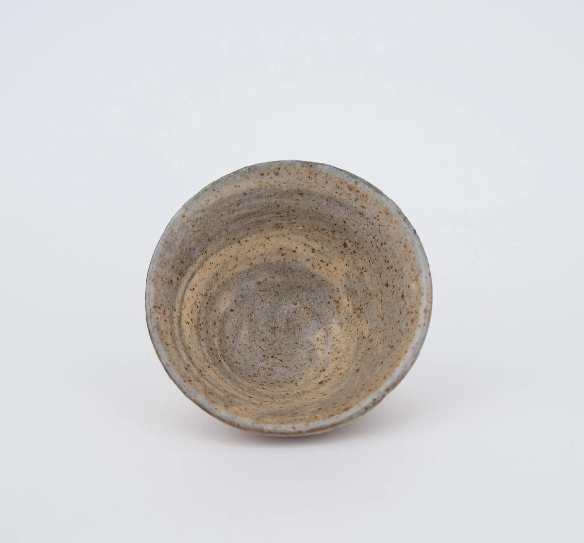 Ceramic teacup with speckled texture on a white background - inside view