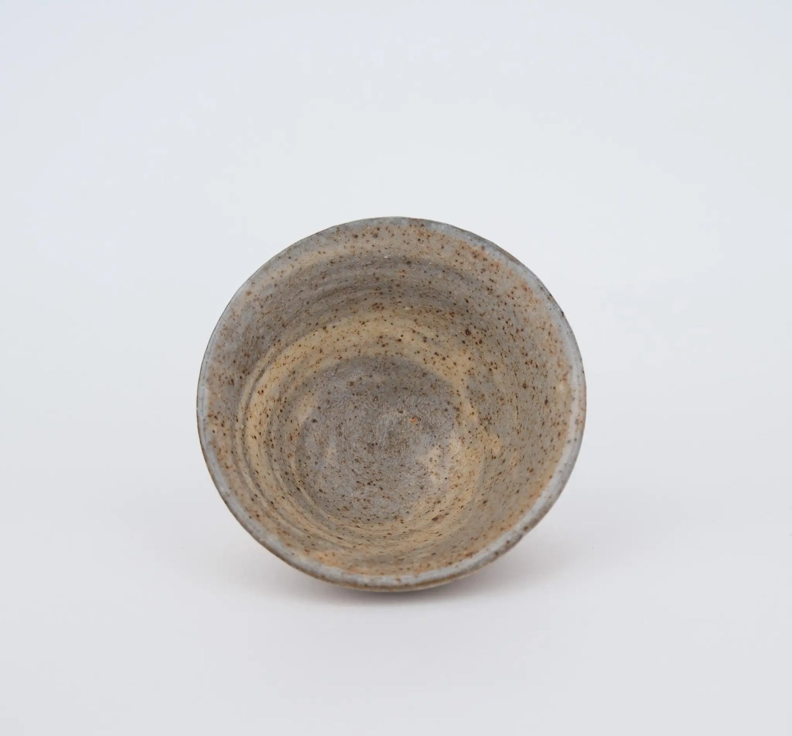 Ceramic teacup with speckled texture on a white background - inside view