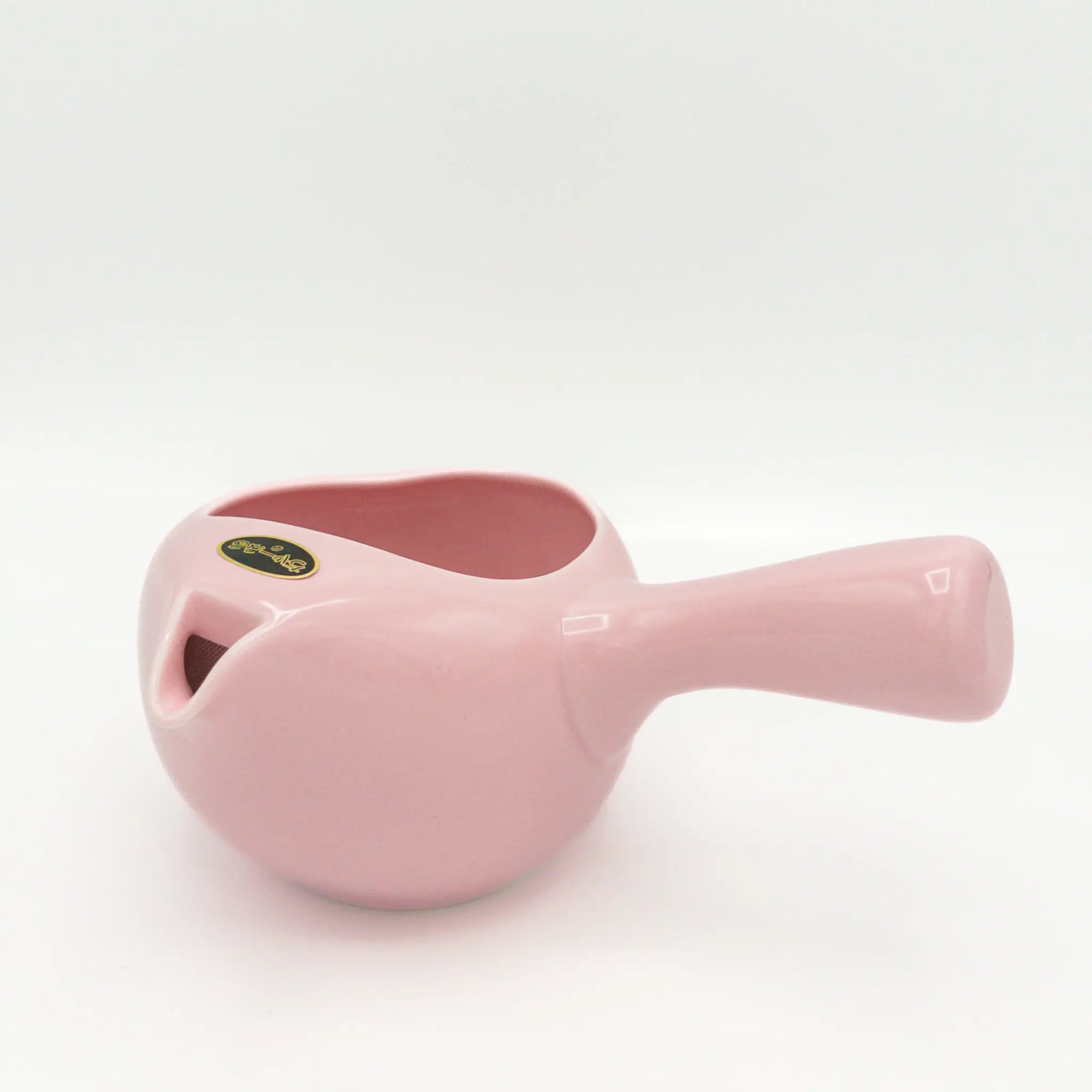 Pink ceramic pot with a handle on a white background