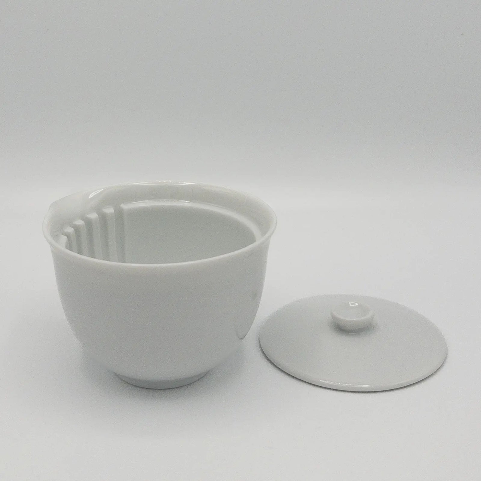 White ceramic hohin teapot with lid off on a white background
