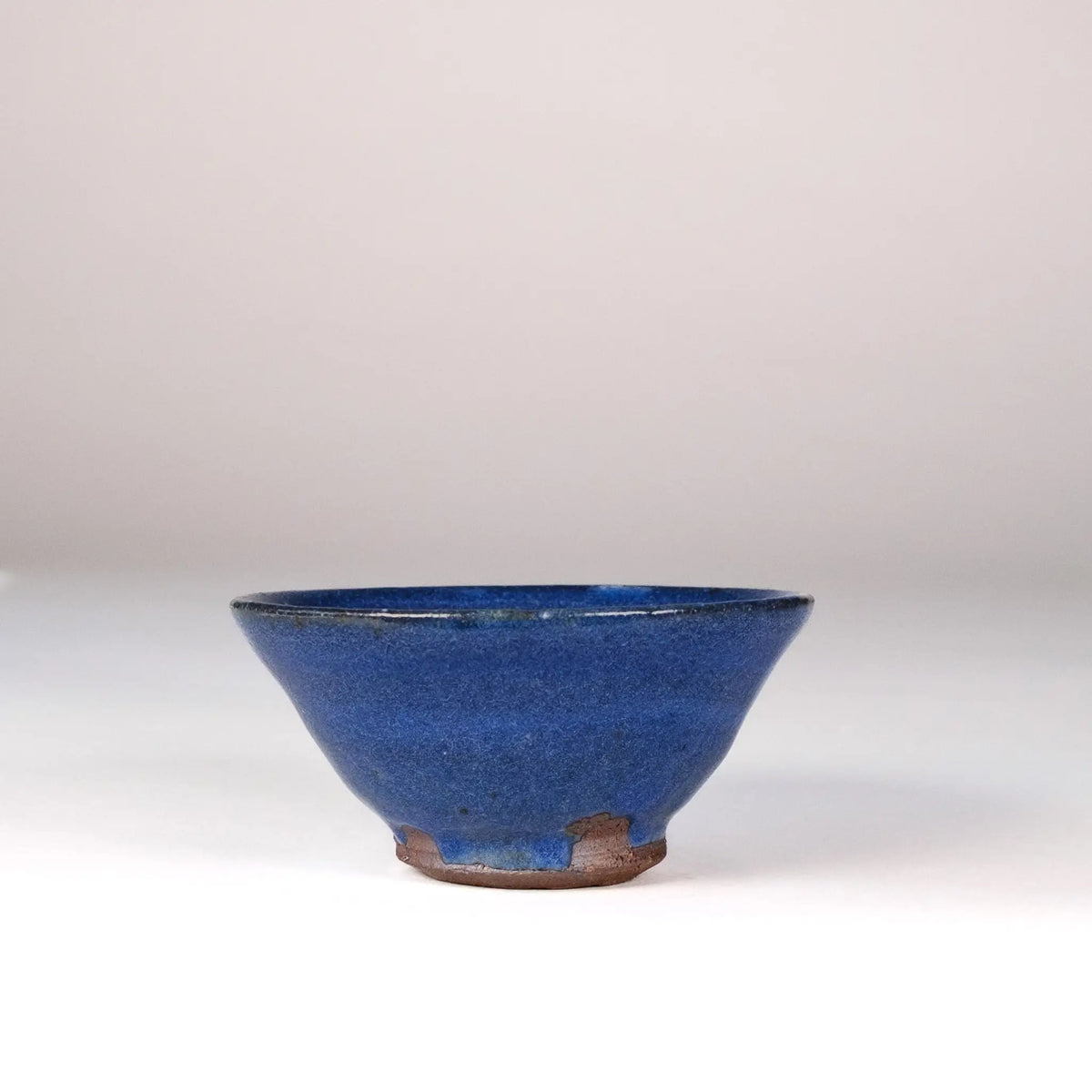 Blue ceramic Mark Mohler teacup on a white background