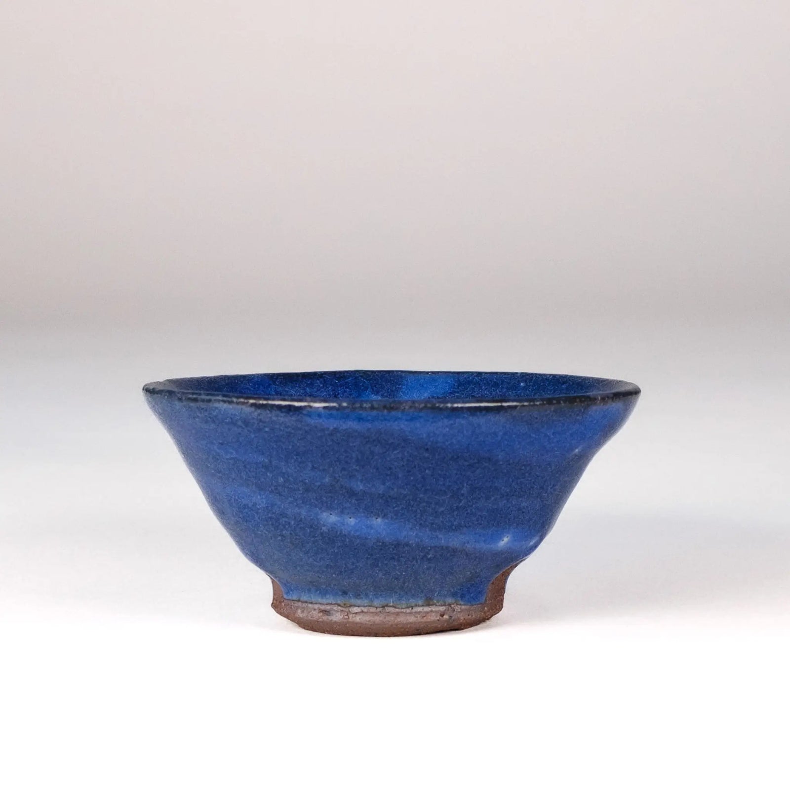 Blue ceramic Mark Mohler teacup on a white background