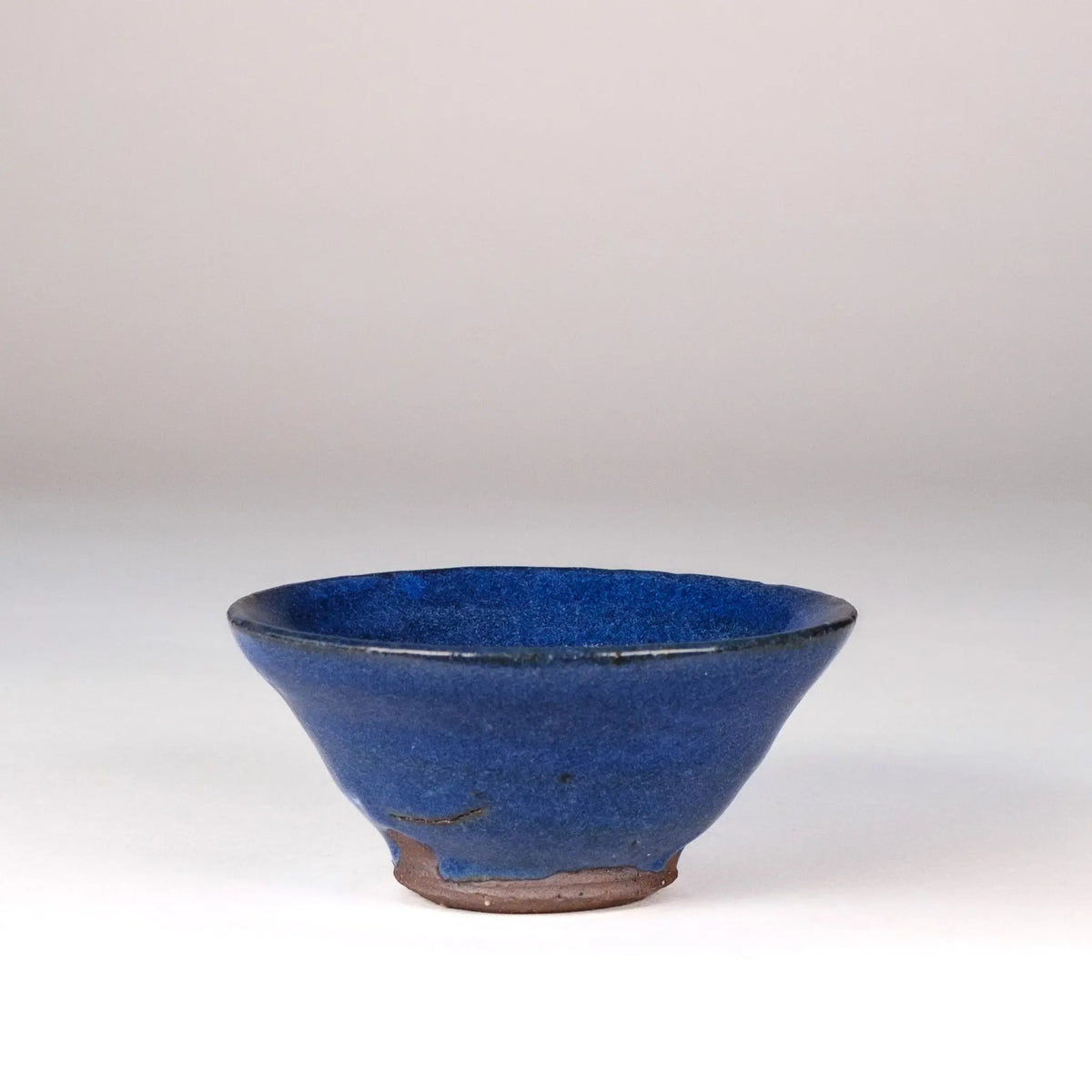 Blue ceramic Mark Mohler teacup on a white background