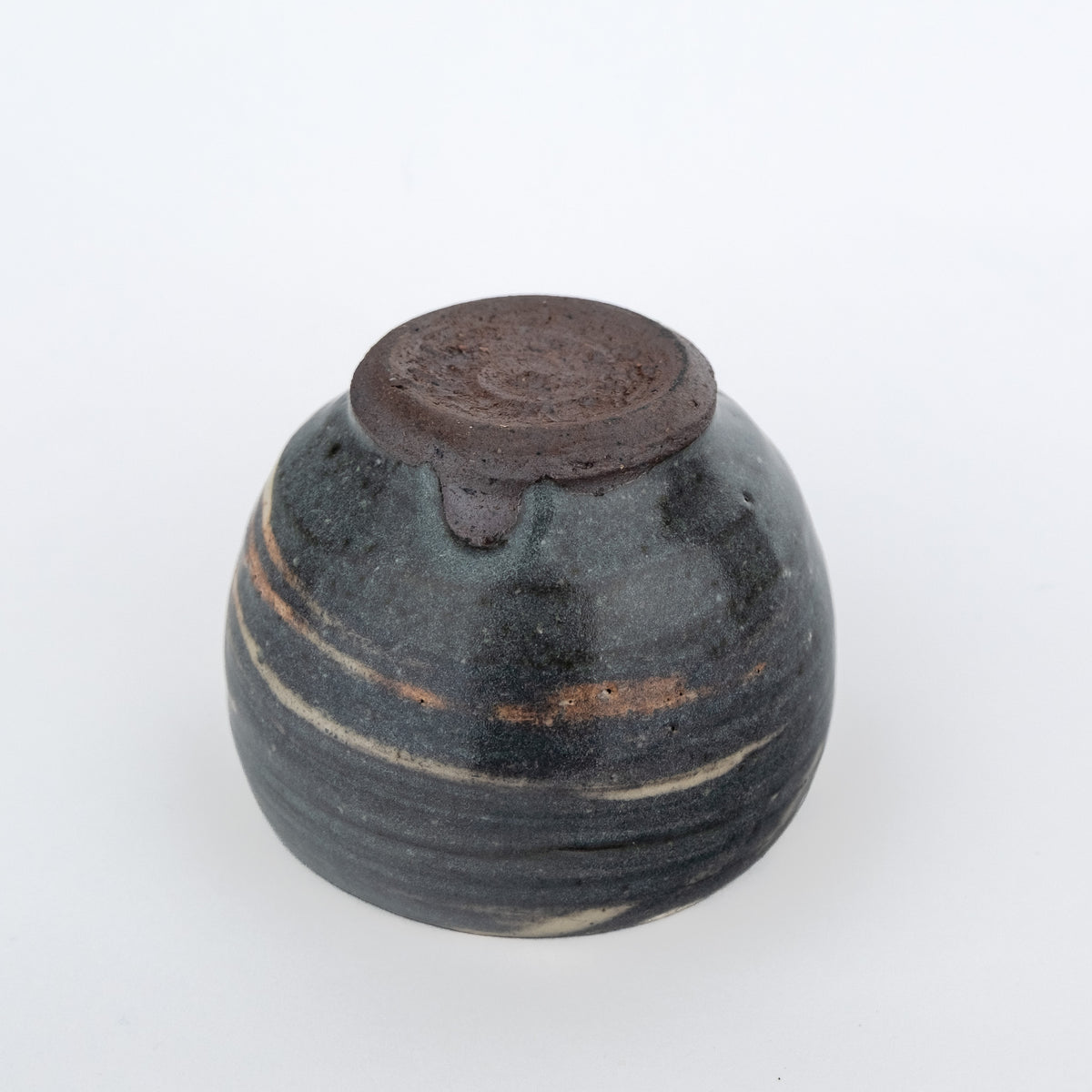 Grey handmade tea cup without a handle and with a white streaky glaze - underside view