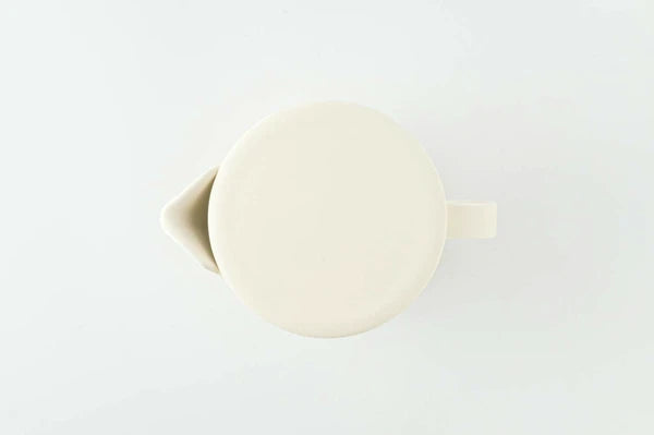 Cream ceramic teapot on a light gray background