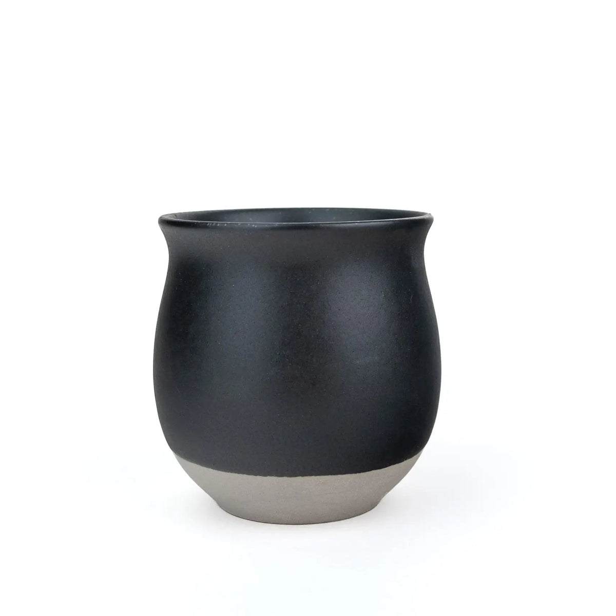 A matte black ceramic cup with a contrasting light gray textured base, photographed against a seamless white background.